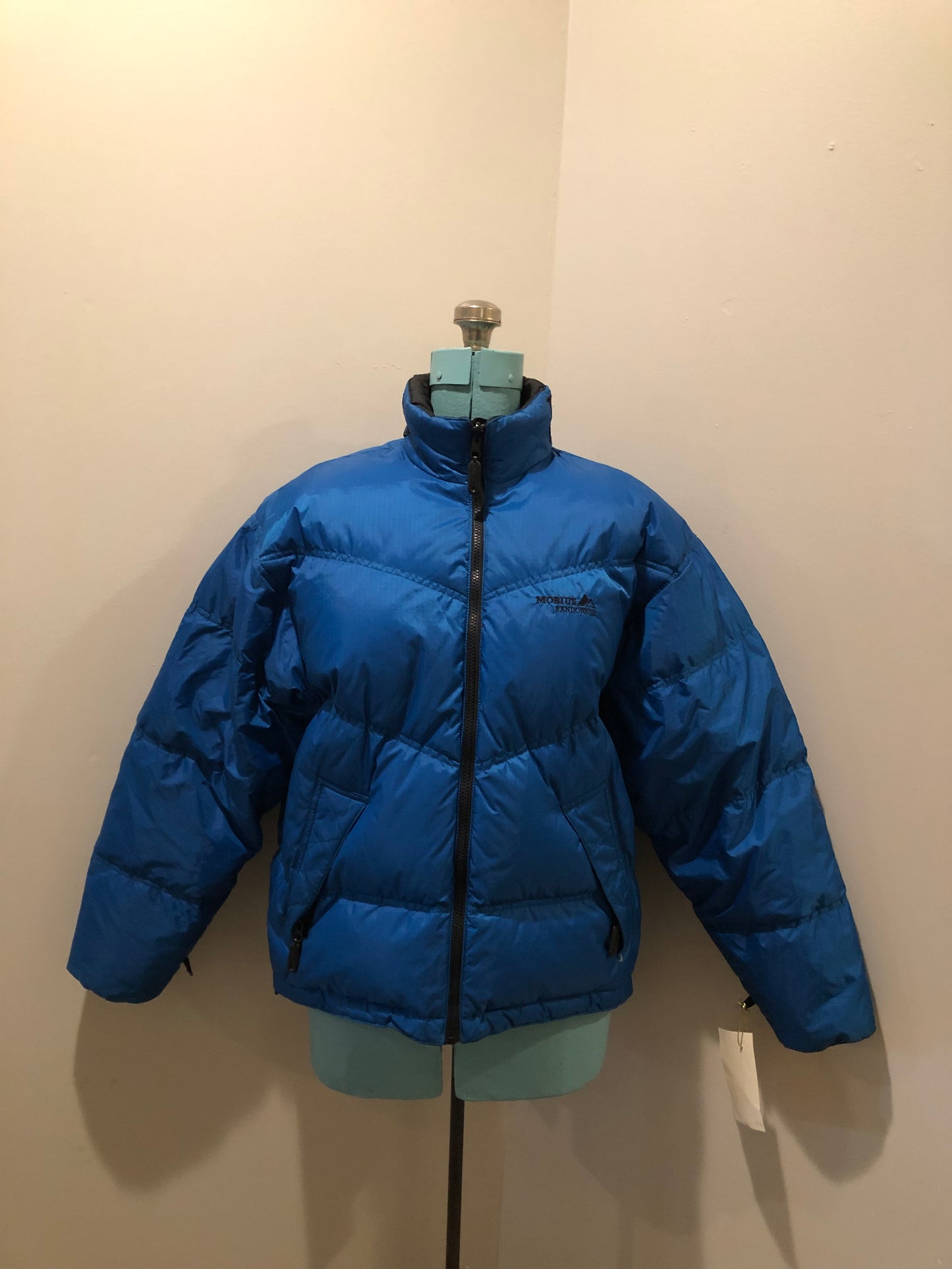 Kingspier Vintage - Vintage Mobius reversible blue and black down filled ski jacket.
This jacket features reversible blue side and black side, zipper closure, two pockets, Logo printed across the back collar,100% polyester shell and 80% down/ 20% feather fill.
Made in Vietnam.
Size Medium.