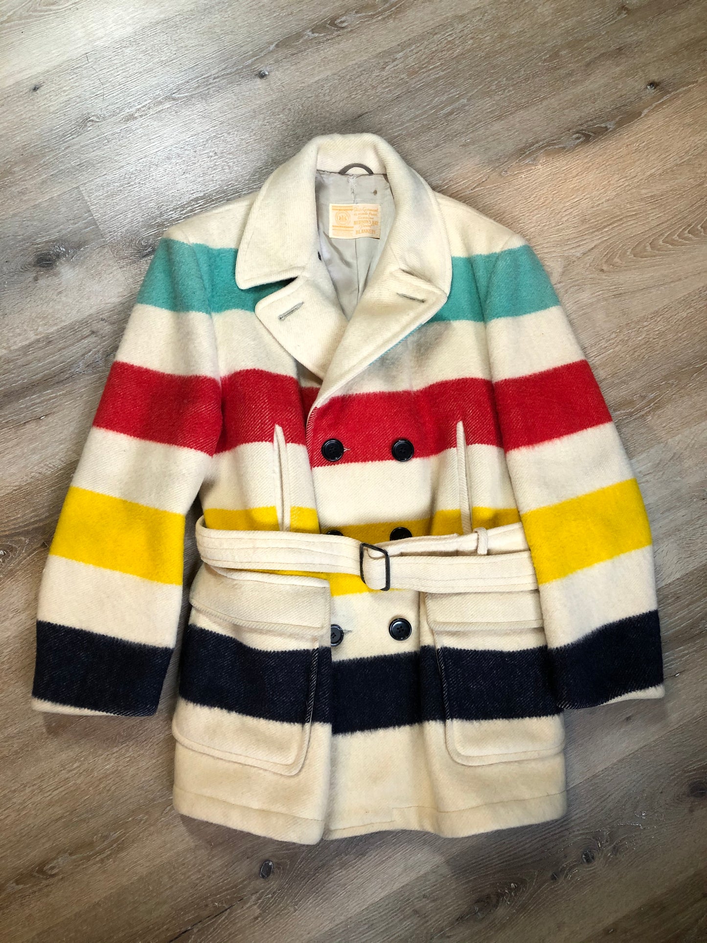 Kingspier Vintage - Genuine Hudson’s Bay Company point blanket coat in the iconic multi stripe colours. The coat features flap pockets and hand warmer pockets, double breasted button closures and belt. Made in Canada. Mens size 50.