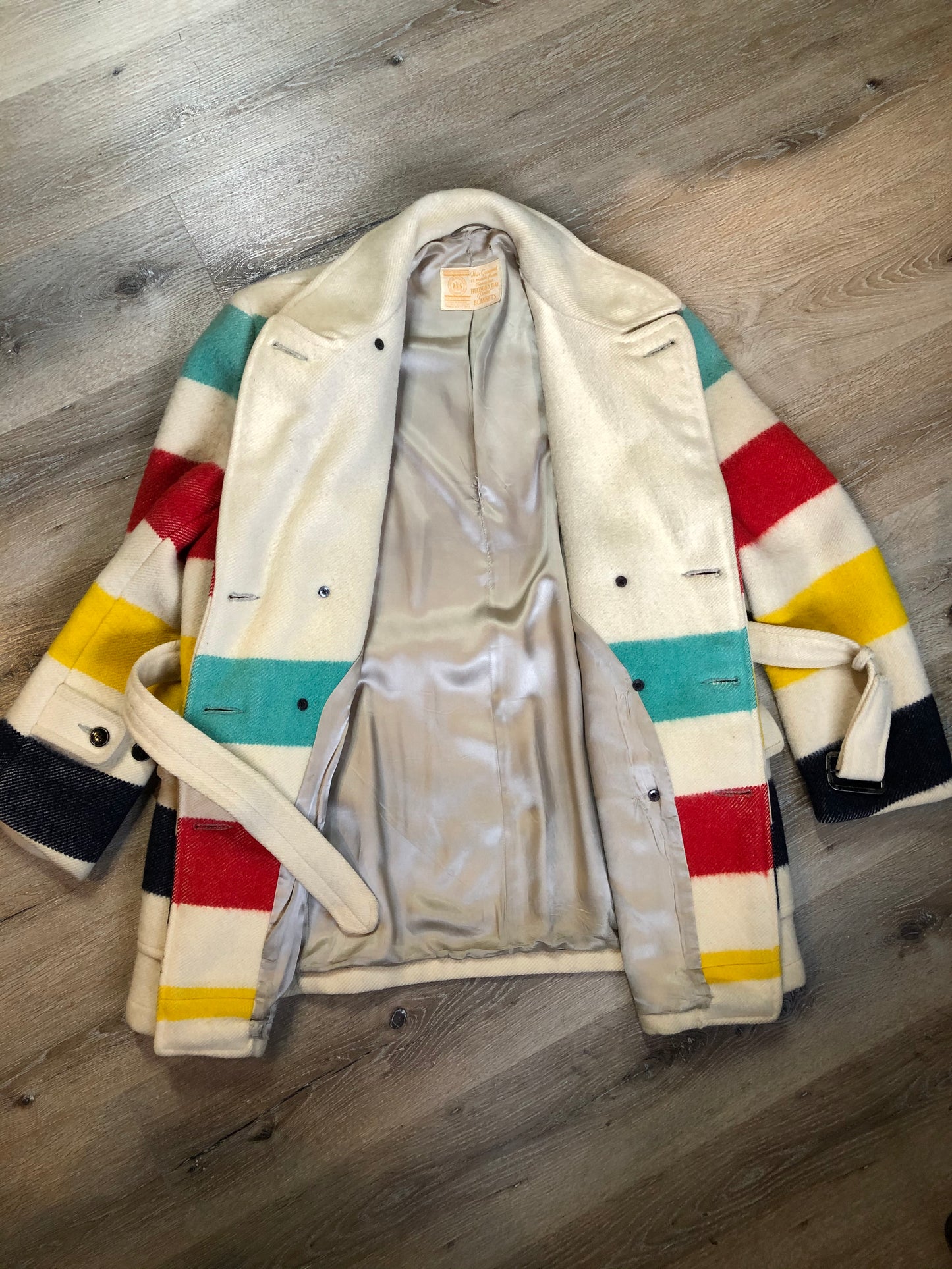 Kingspier Vintage - Genuine Hudson’s Bay Company point blanket coat in the iconic multi stripe colours. The coat features flap pockets and hand warmer pockets, double breasted button closures and belt. Made in Canada. Mens size 50.