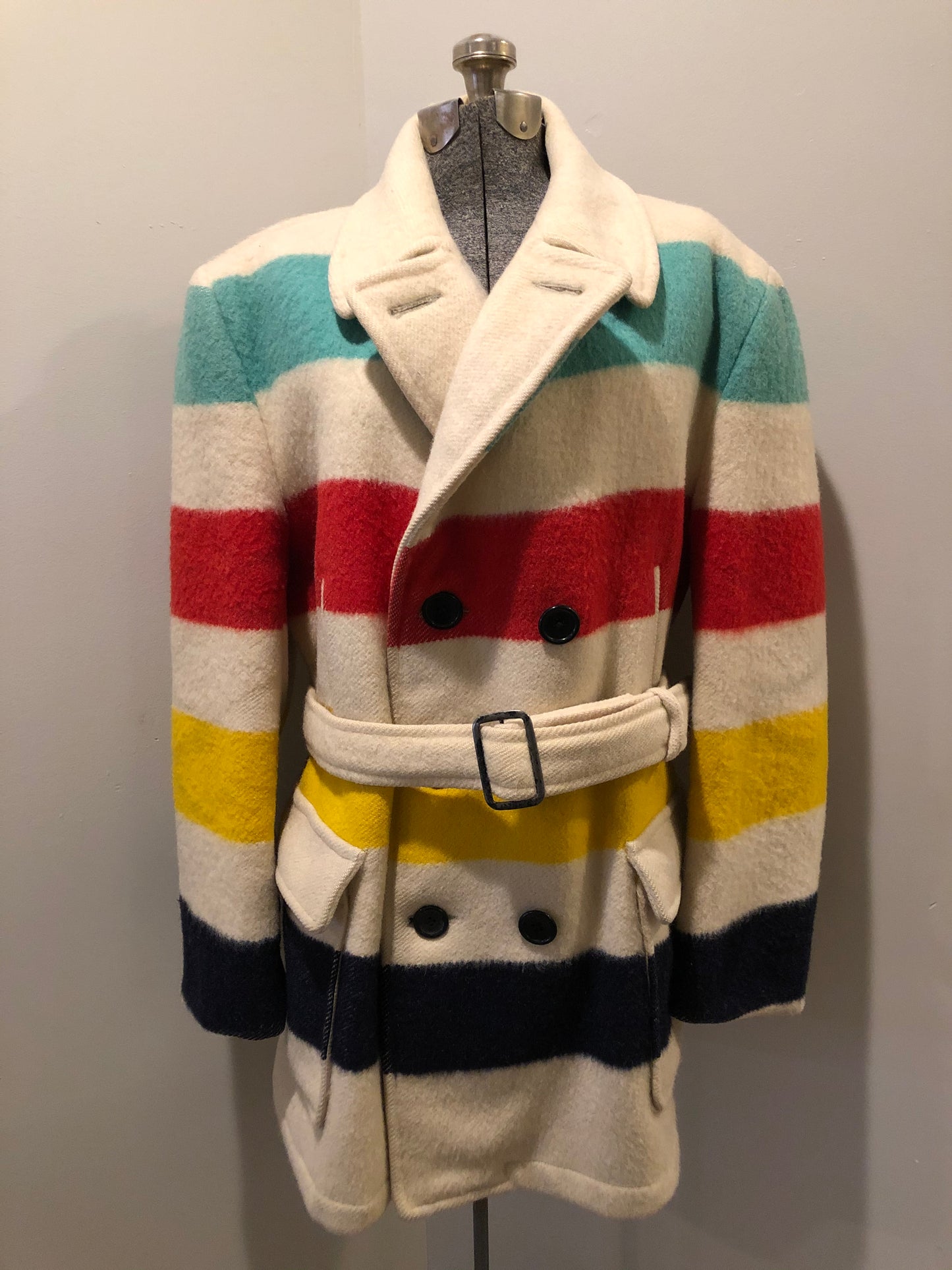 Kingspier Vintage - Genuine Hudson’s Bay Company point blanket coat in the iconic multi stripe colours. The coat features flap pockets and hand warmer pockets, double breasted button closures and belt. Made in Canada. Mens size 50.