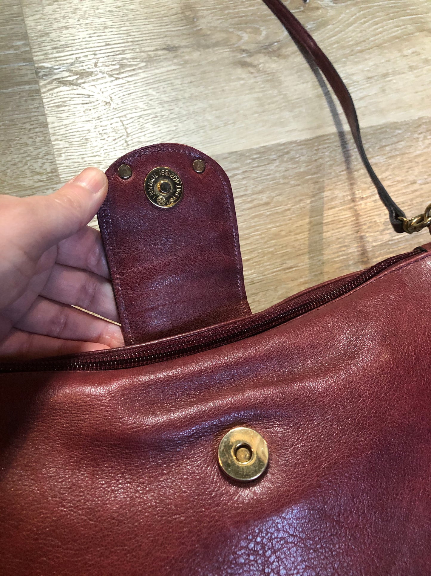 Kingspier Vintage - Etienne Aigner leather crossbody bag with brass hardware, zipper top closure and snap front closure.