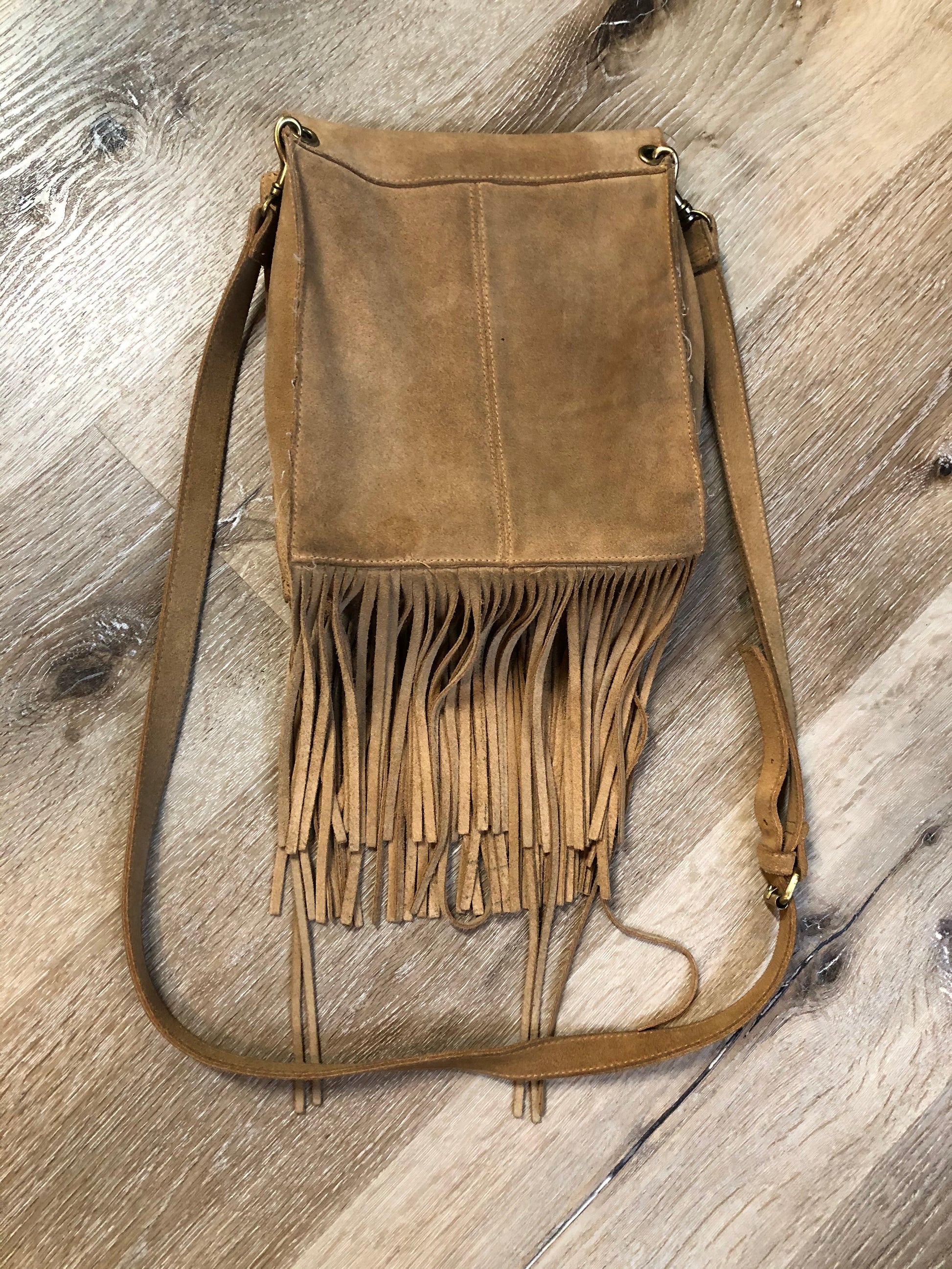 Kingspier Vintage - Suede crossbody bag with fringe, adjustable strap and snap closure.