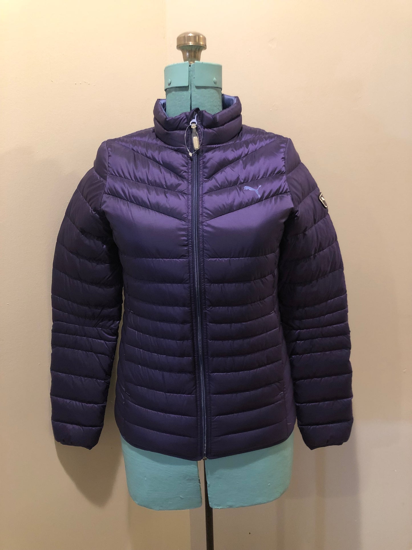 Kingspier Vintage -Puma packable slim fit down filled jacket with zipper closure, two front pockets, nylon shell and 90% down/ 10% feather fill.
Size small.