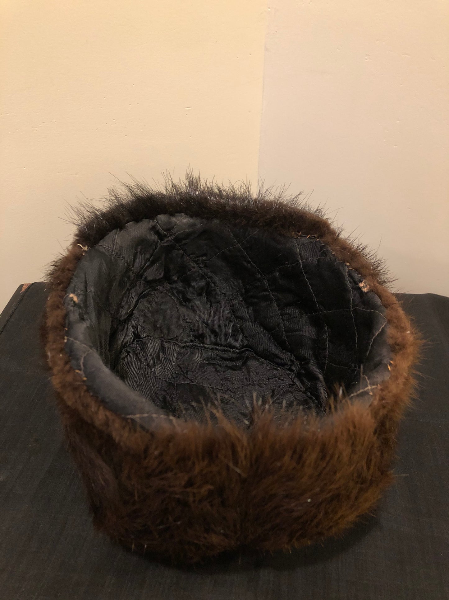 Kingspier Vintage - Dark brown fur hat with front flap and quilted lining.
Circumference - 21.5”
Hat is in good condition with some overall wear.