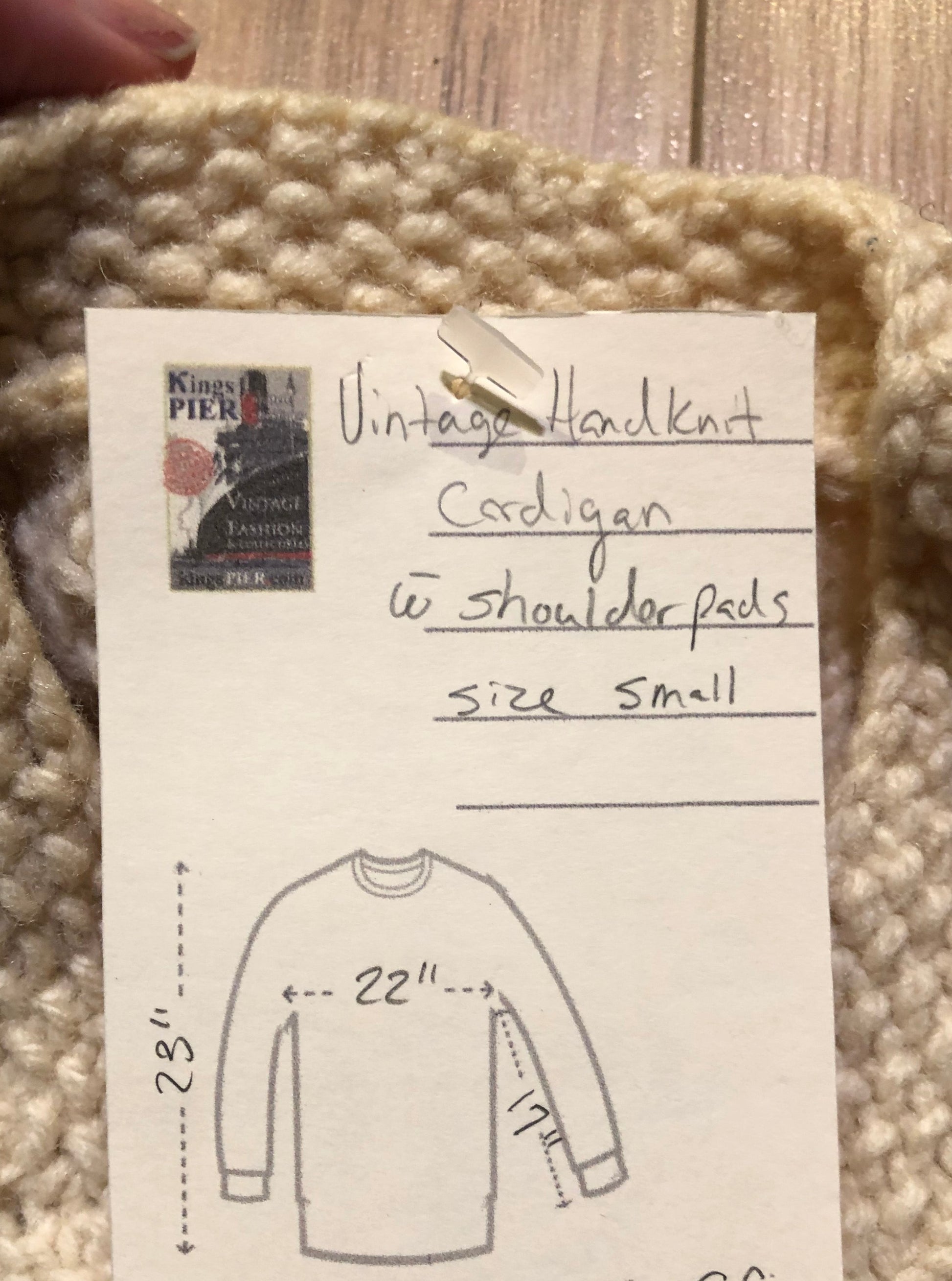 Kingspier Vintage - Vintage hand-knit cream coloured cardigan with buttons and shoulder pads.
Size small.