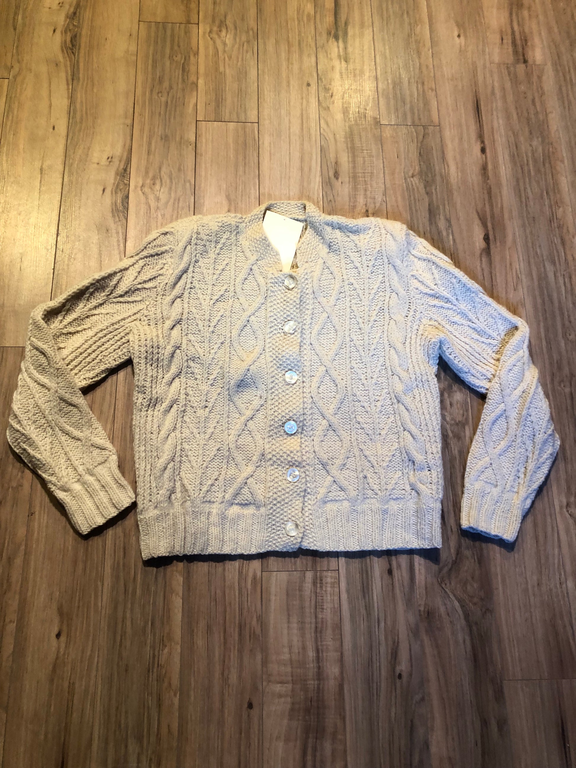 Kingspier Vintage - Vintage hand-knit cream coloured cardigan with buttons and shoulder pads.
Size small.