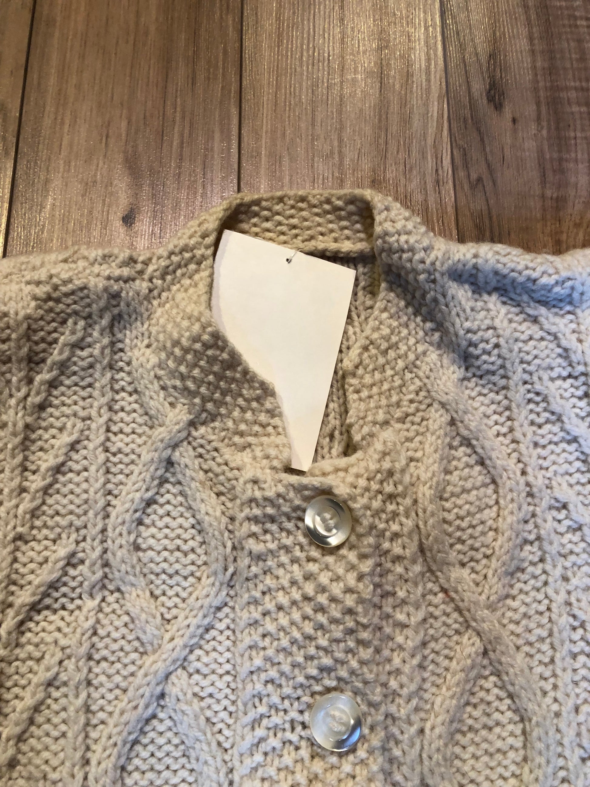 Kingspier Vintage - Vintage hand-knit cream coloured cardigan with buttons and shoulder pads.
Size small.