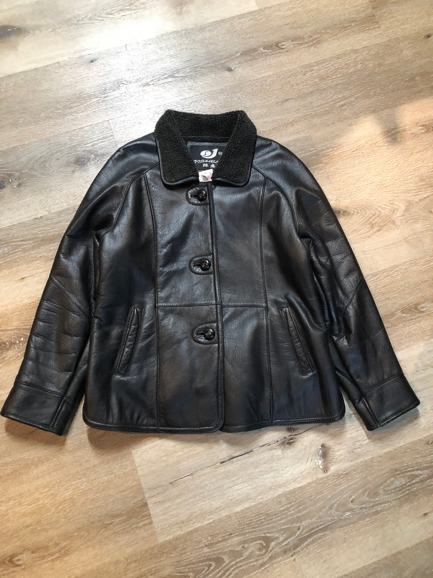 Kingspier Vintage - Contemporary black leather flight style jacket with synthetic wool pile lining , button closures and slash pockets.