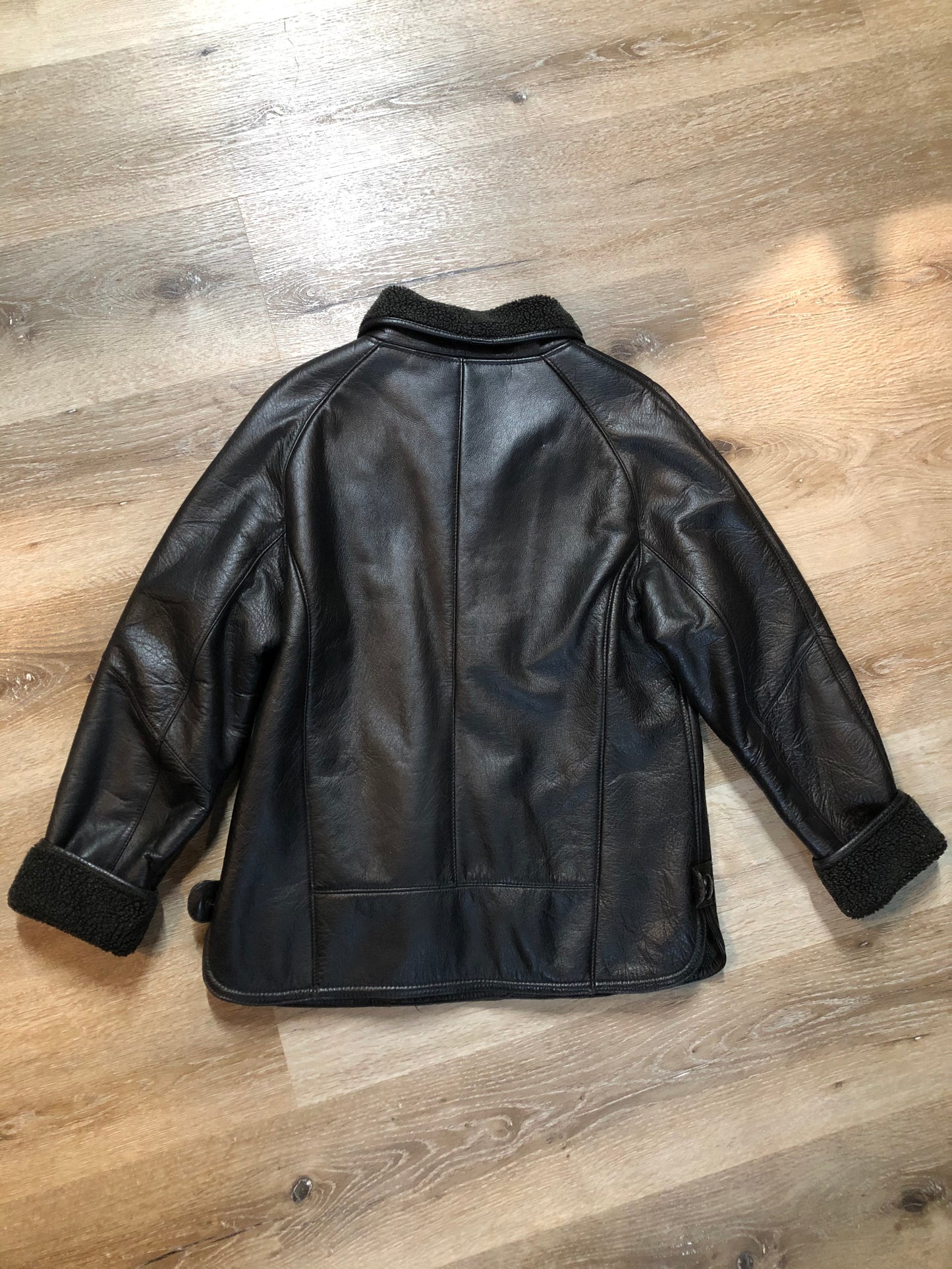 Kingspier Vintage - Contemporary black leather flight style jacket with synthetic wool pile lining , button closures and slash pockets.