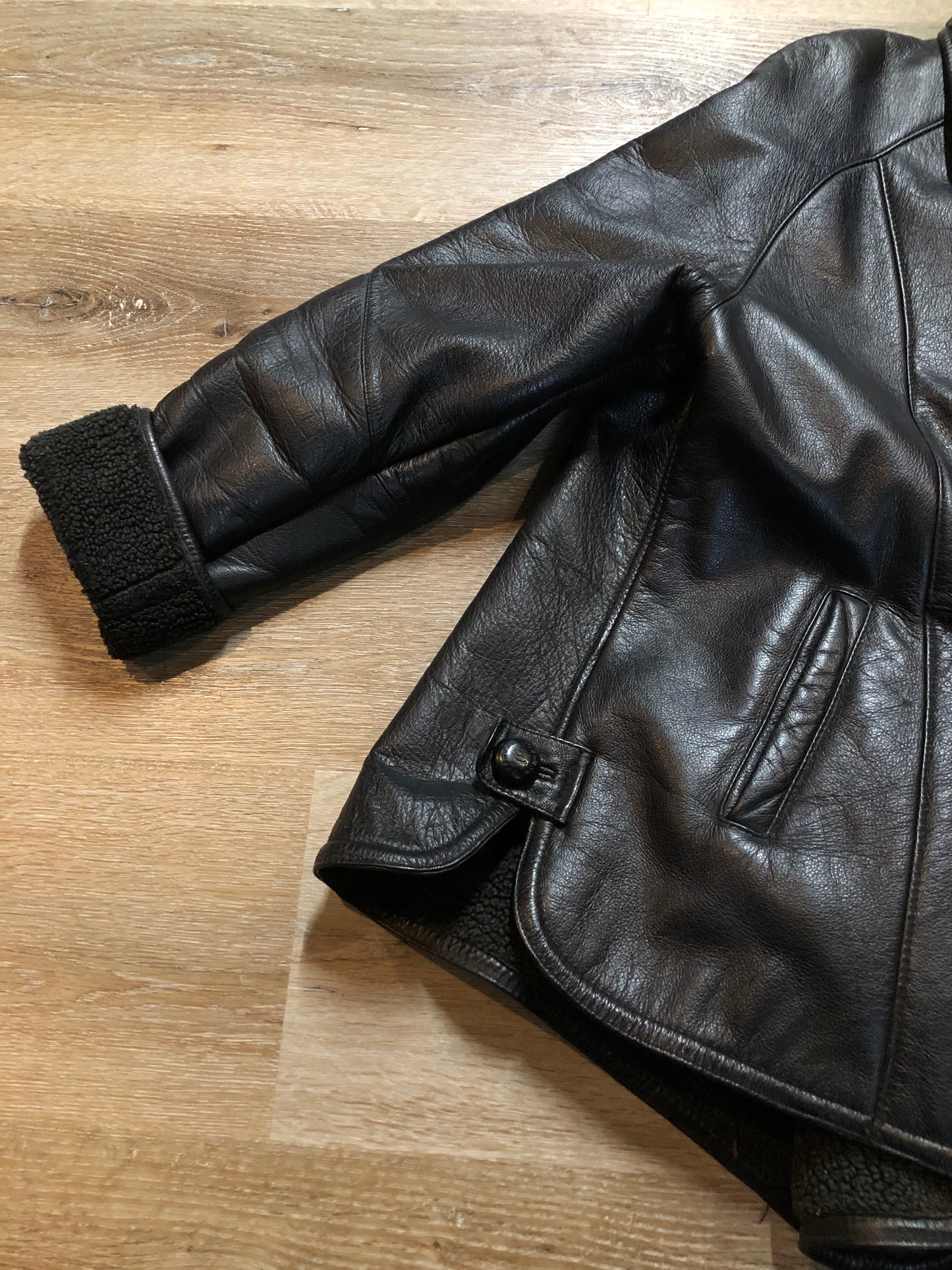 Kingspier Vintage - Contemporary black leather flight style jacket with synthetic wool pile lining , button closures and slash pockets.