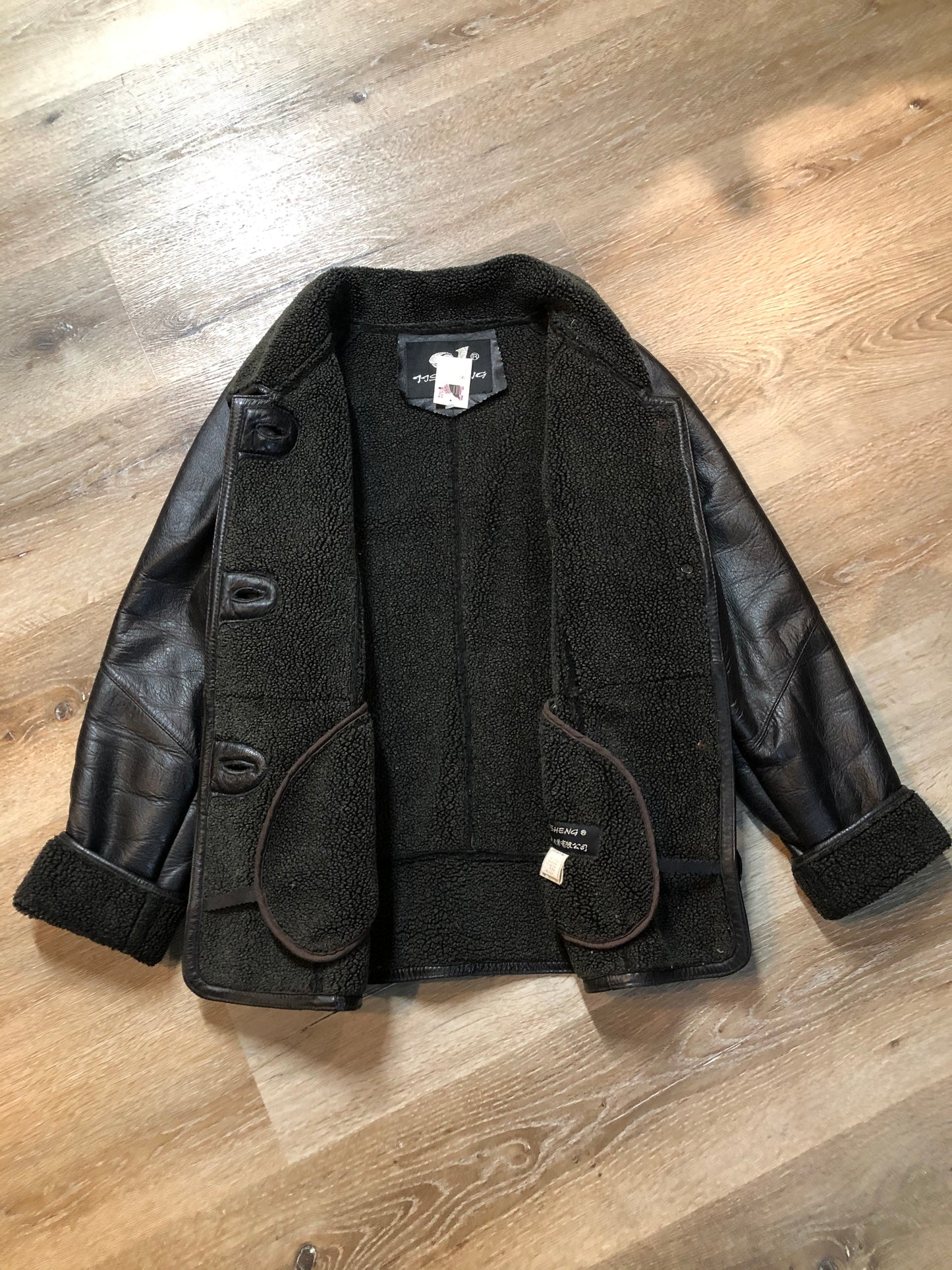 Kingspier Vintage - Contemporary black leather flight style jacket with synthetic wool pile lining , button closures and slash pockets.