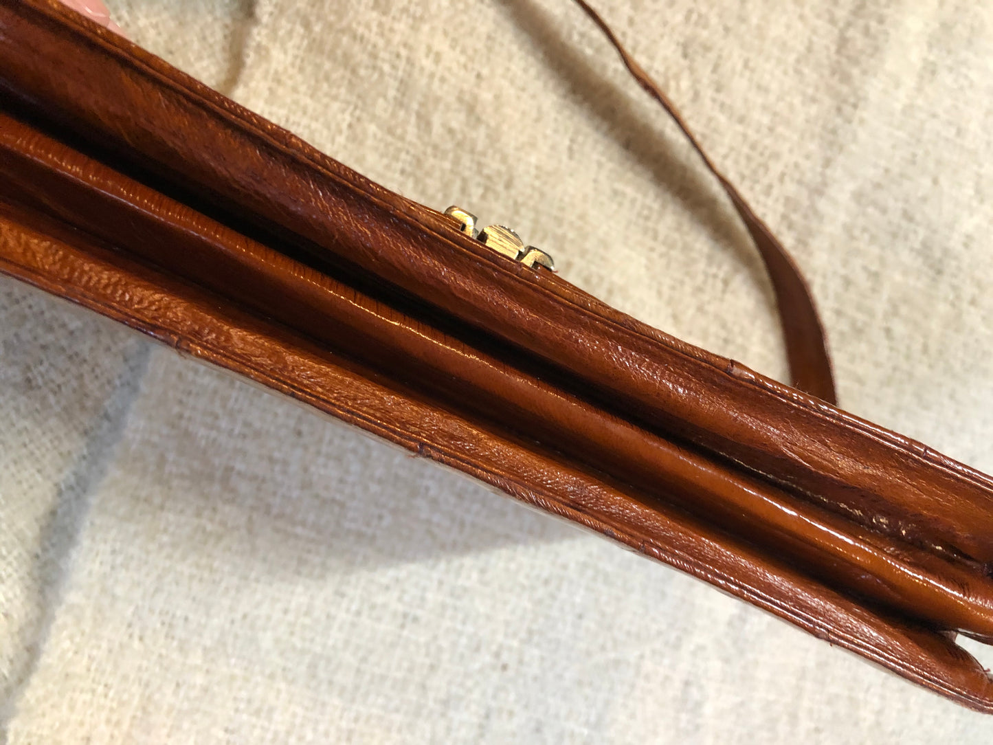 Kingspier Vintage - Vintage satchel in very soft caramel colour leather with gathered leather details, a unique front clasp, brass hardware and three inside compartments. 
Length - 12”
Width - 1”
Height - 7.5”
Strap - 30.5”
This purse is in excellent condition.