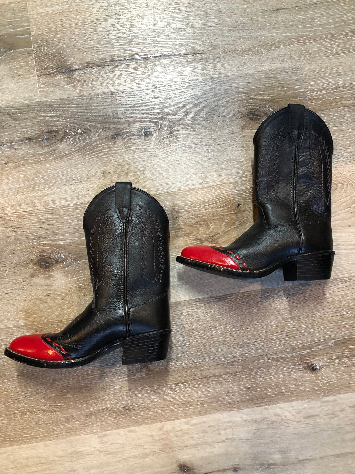 Kingspier Vintage - Kids black cowboy boot with red toe and decorative stitching.
Size kids 3