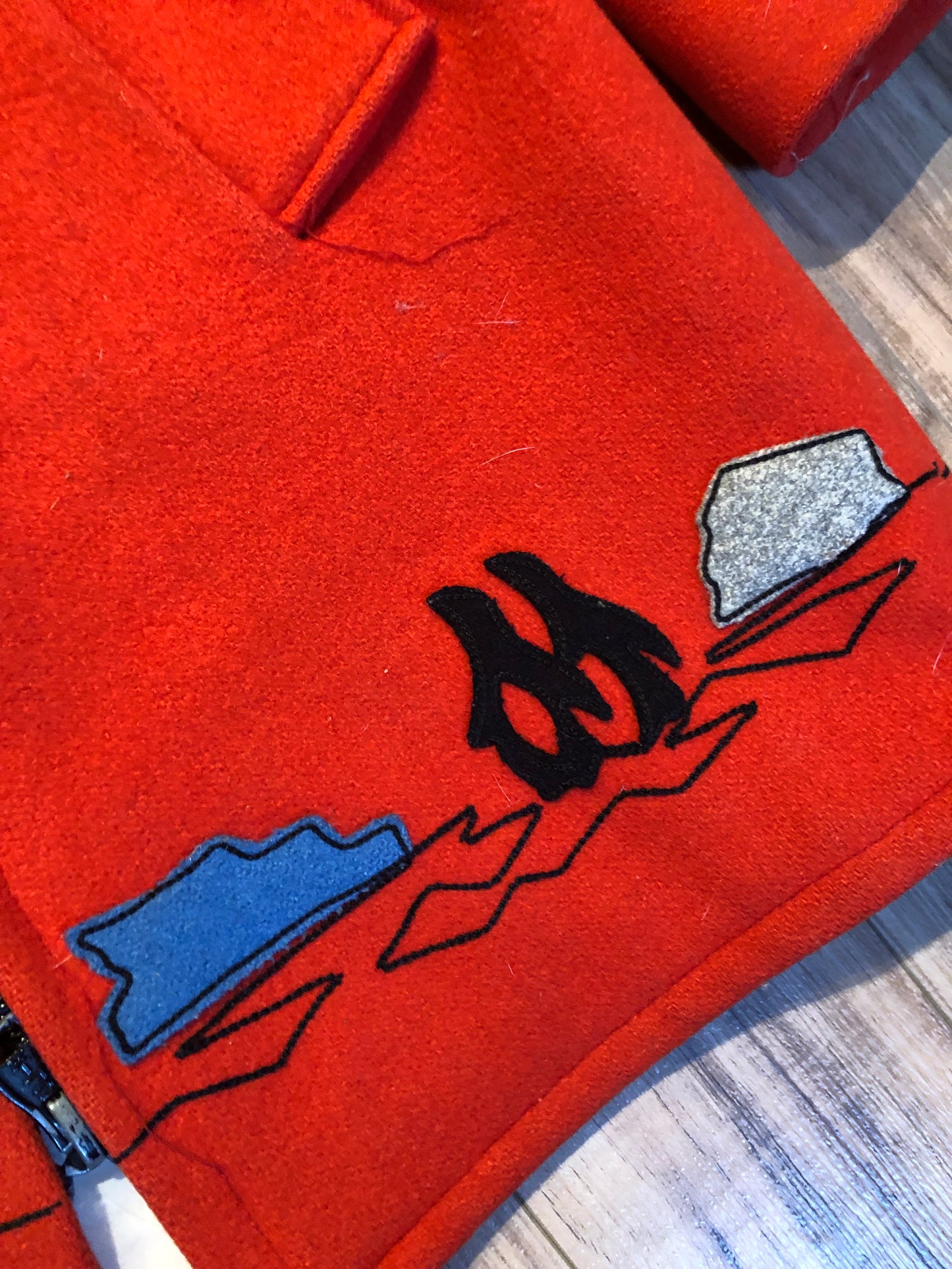 Kingspier Vintage - Vintage James Bay 100% virgin wool northern parka in bright red. This parka features a fur trimmed hood, zipper closure, pockets, quilted lining, storm cuffs, and penguin scene in felt applique. Made in Canada.