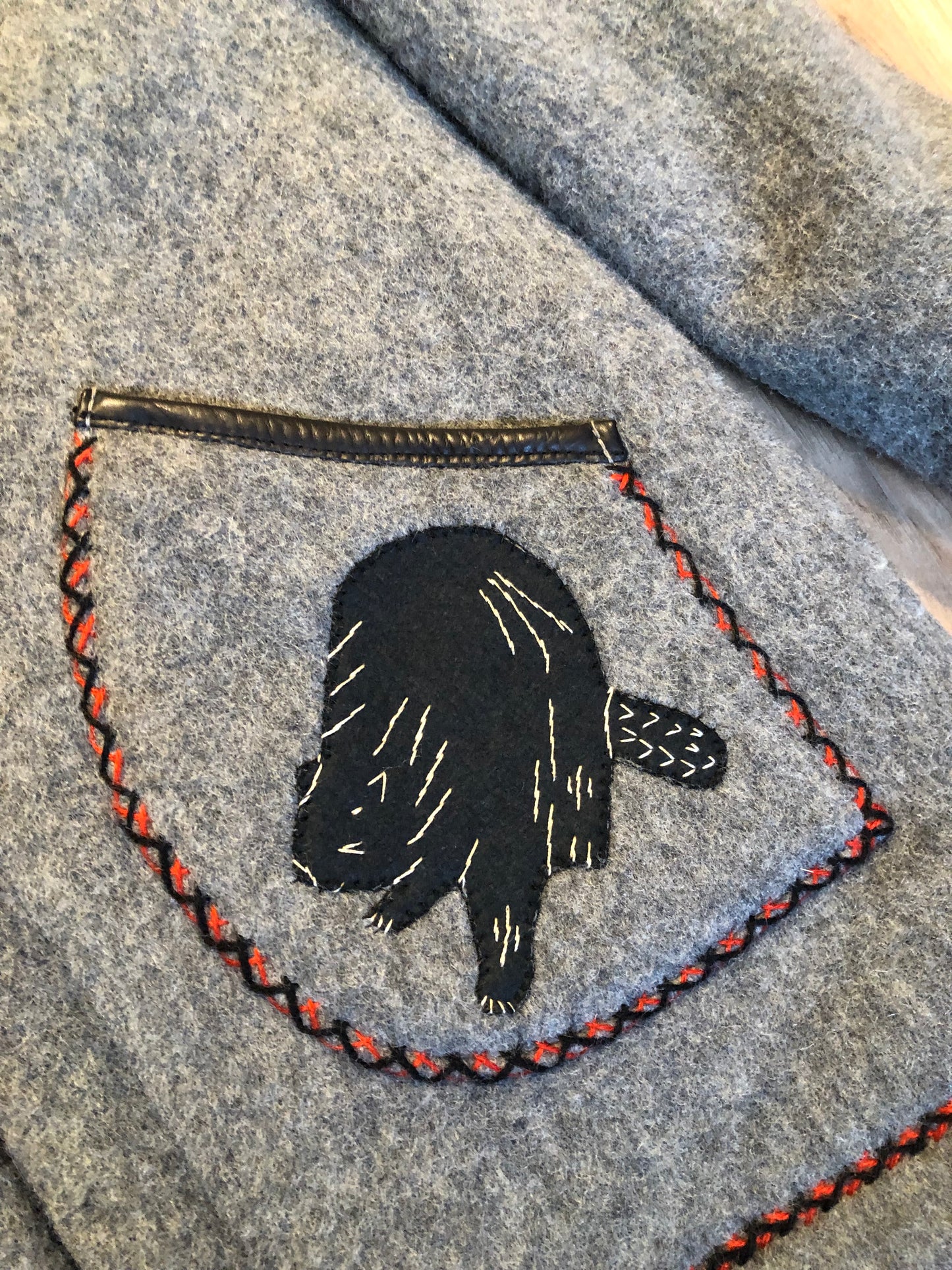 Kingspier Vintage - Vintage James Bay 100% virgin wool northern parka in grey. This parka features a fur trimmed hood, zipper closure, patch pockets, quilted lining, storm cuffs, leather trim, custom embroidery and a beaver design in felt applique.
Made in Canada.
Size small.