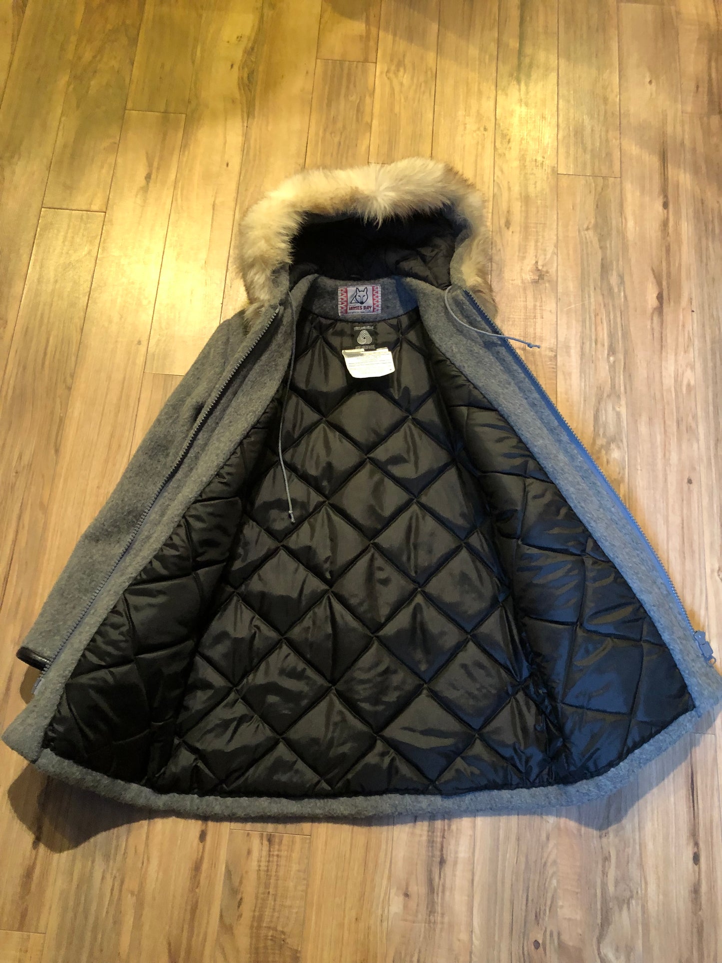 Kingspier Vintage - Vintage James Bay 100% virgin wool northern parka in grey. This parka features a fur trimmed hood, zipper closure, patch pockets, quilted lining, storm cuffs, leather trim, custom embroidery and a beaver design in felt applique.
Made in Canada.
Size small.