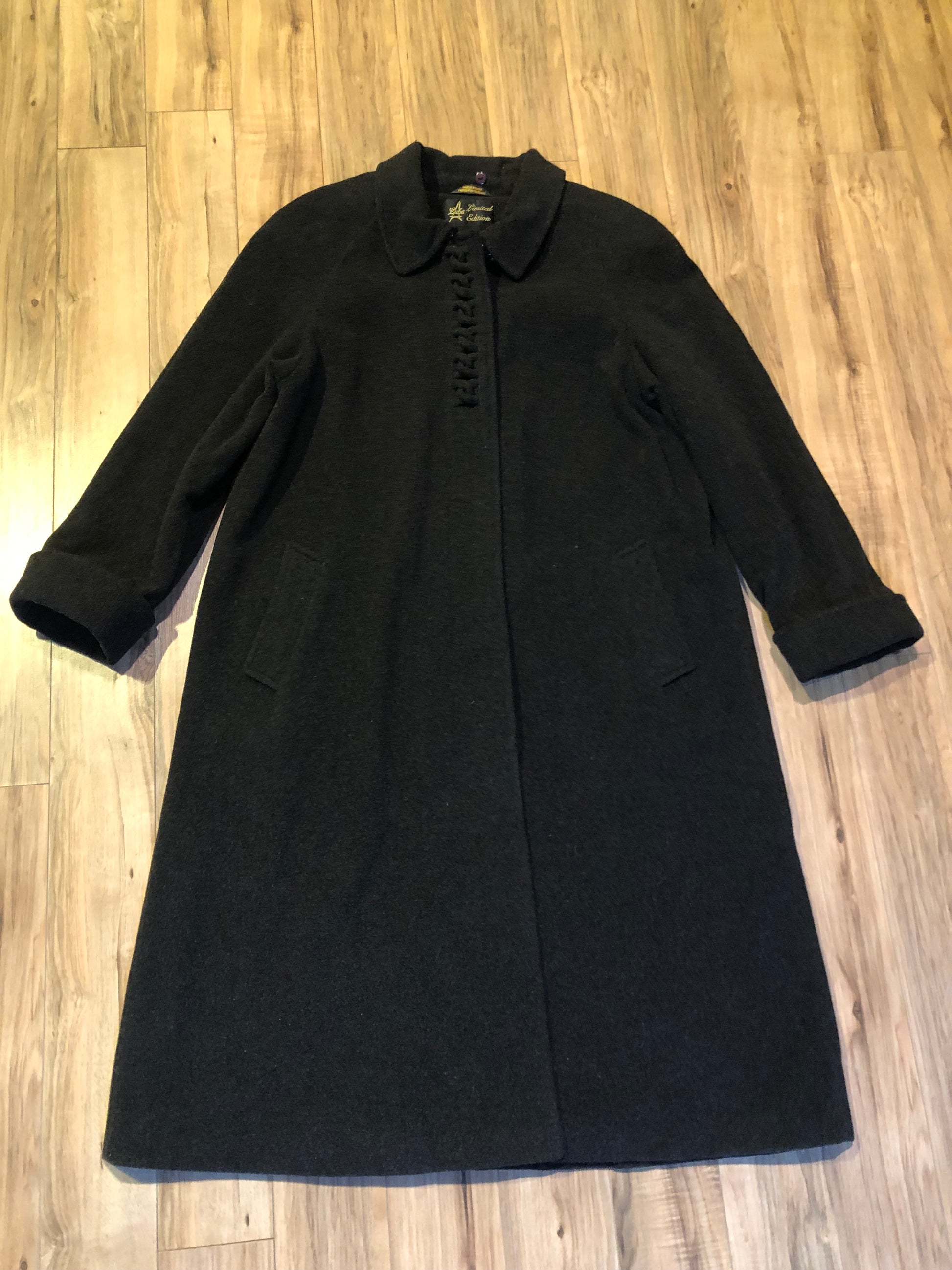 Kingspier Vintage - Vintage Luba limited edition lambswool blend long black coat with woven detail on the front, button closures, two pockets in the front and a satin lining.
Made in Romania.
Size 16.