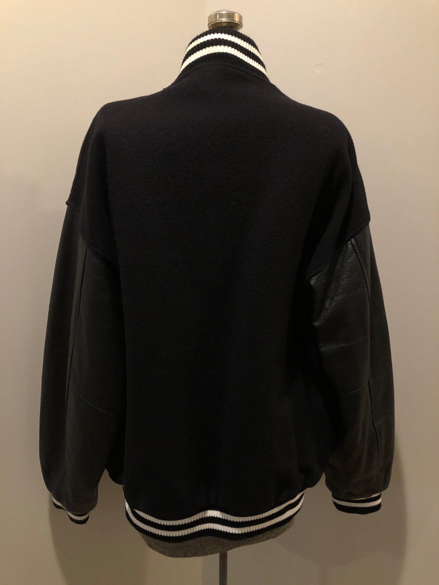 Kingspier Vintage - Coors Light black wool blend varsity jacket with black leather arms, knit trim, slash pockets, snap closure and a quilted lining. Men’s XL.
