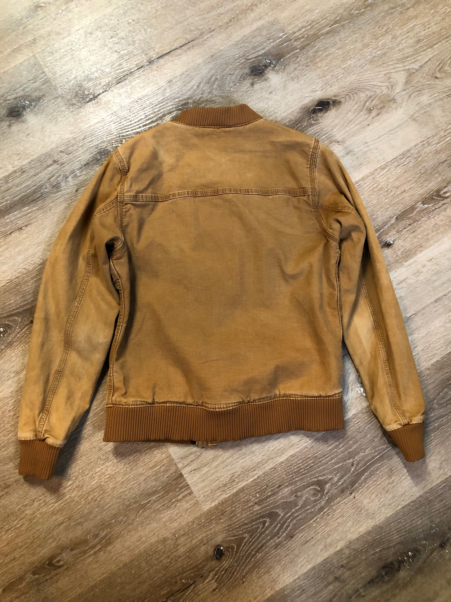 Kingspier Vintage - Carhartt tan bomber jacket with zipper closure, pockets, vertical zip pocket on chest, inside pocket and a lightweight lining. Women’s small.