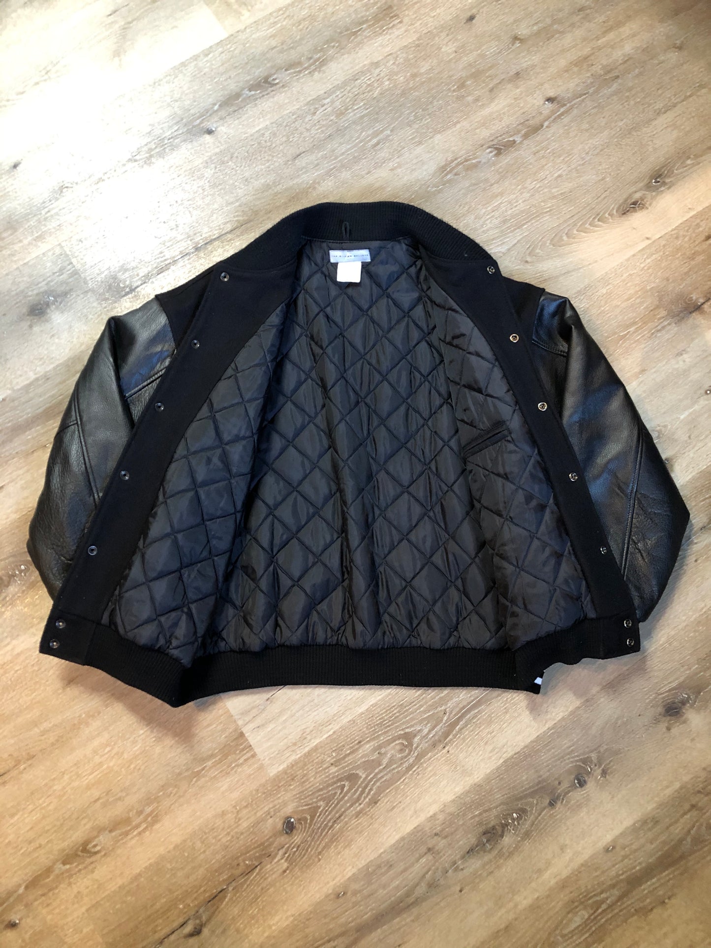 Kingspier Vintage - Coors Light black wool blend varsity jacket with black leather arms, knit trim, slash pockets, snap closure and a quilted lining. Men’s XL.