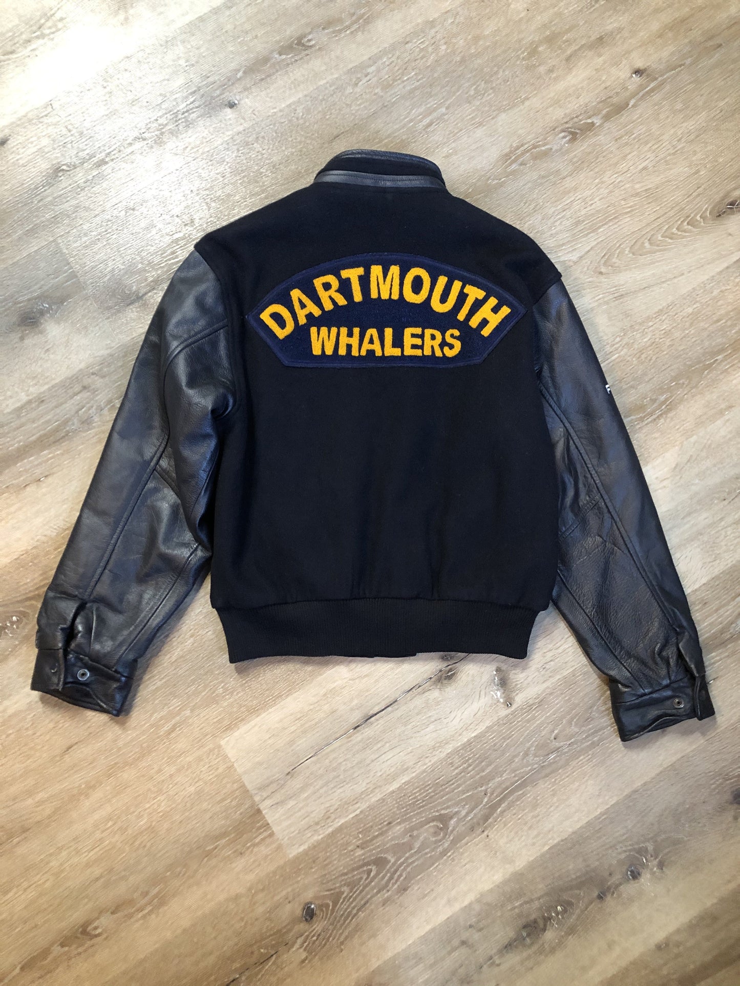 Kingspier Vintage - Dartmouth Whalers navy blue wool blend with leather trim varsity jacket. Jacket features Dartmouth whalers emblem on the chest and the back, “defence” embroidered on the left sleeve and “Forbes” embroidered on the right sleeve, insulated lining, two inside pockets, two slash pockets, zipper and snap closures. Made by Canada sportswear. Size small.