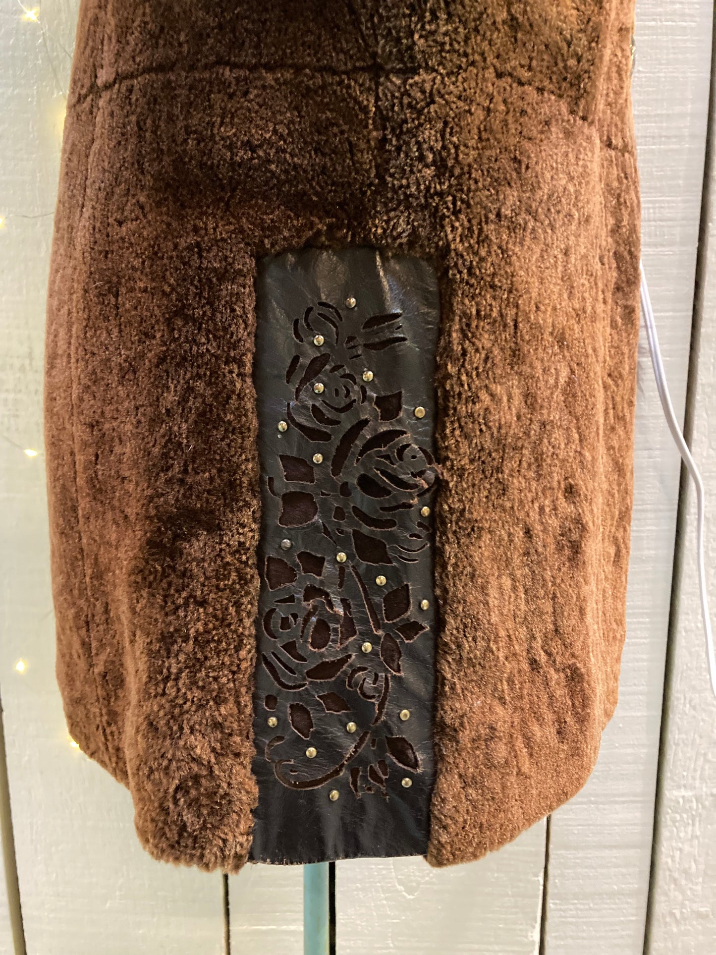 Kingspier Vintage - Vintage Weitral shearling coat with fur trimmed hood and cuffs, unique button closures, leather details with floral motif and two front pockets.
Size large.
Made in Russia.