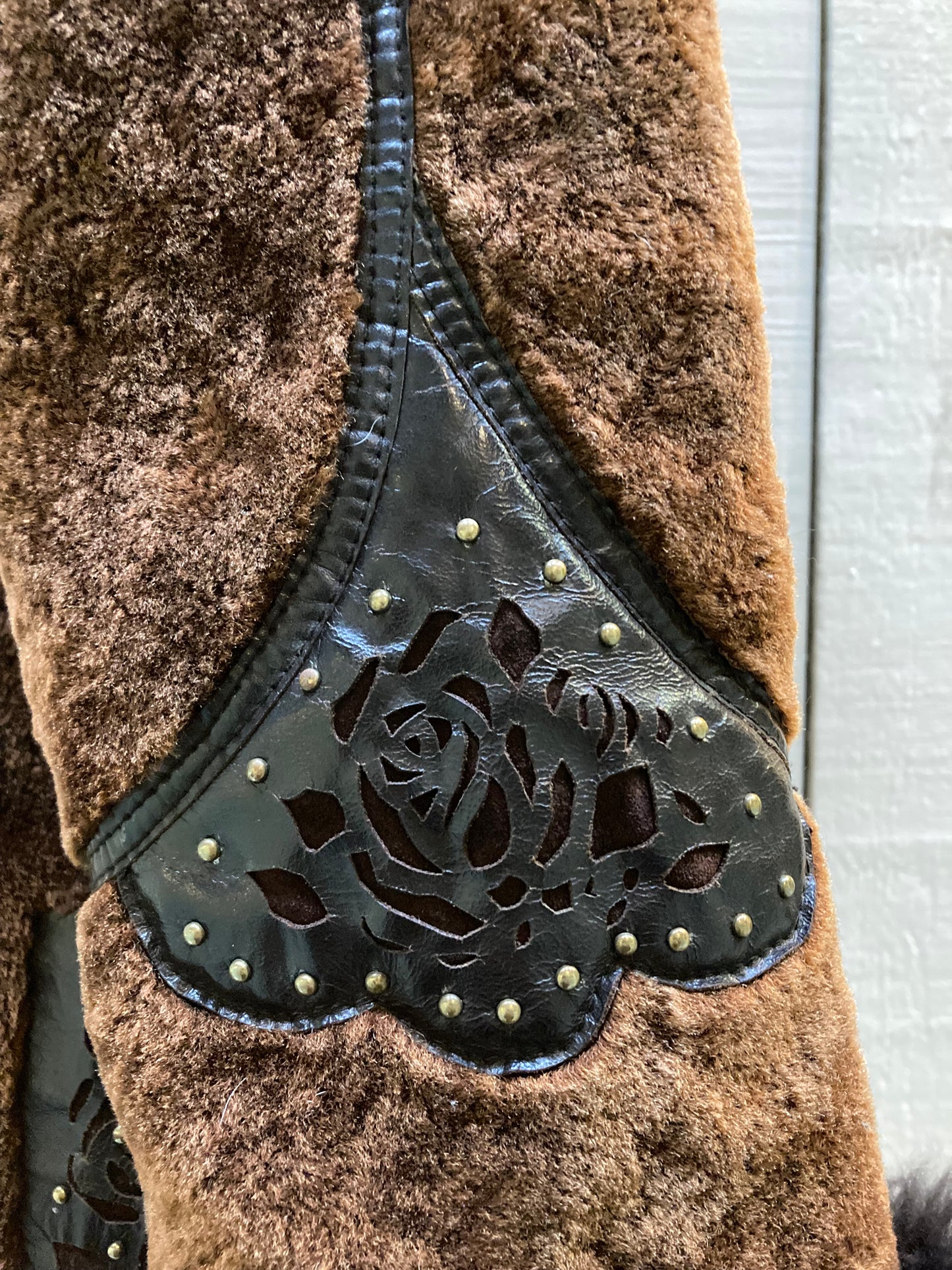 Kingspier Vintage - Vintage Weitral shearling coat with fur trimmed hood and cuffs, unique button closures, leather details with floral motif and two front pockets.
Size large.
Made in Russia.