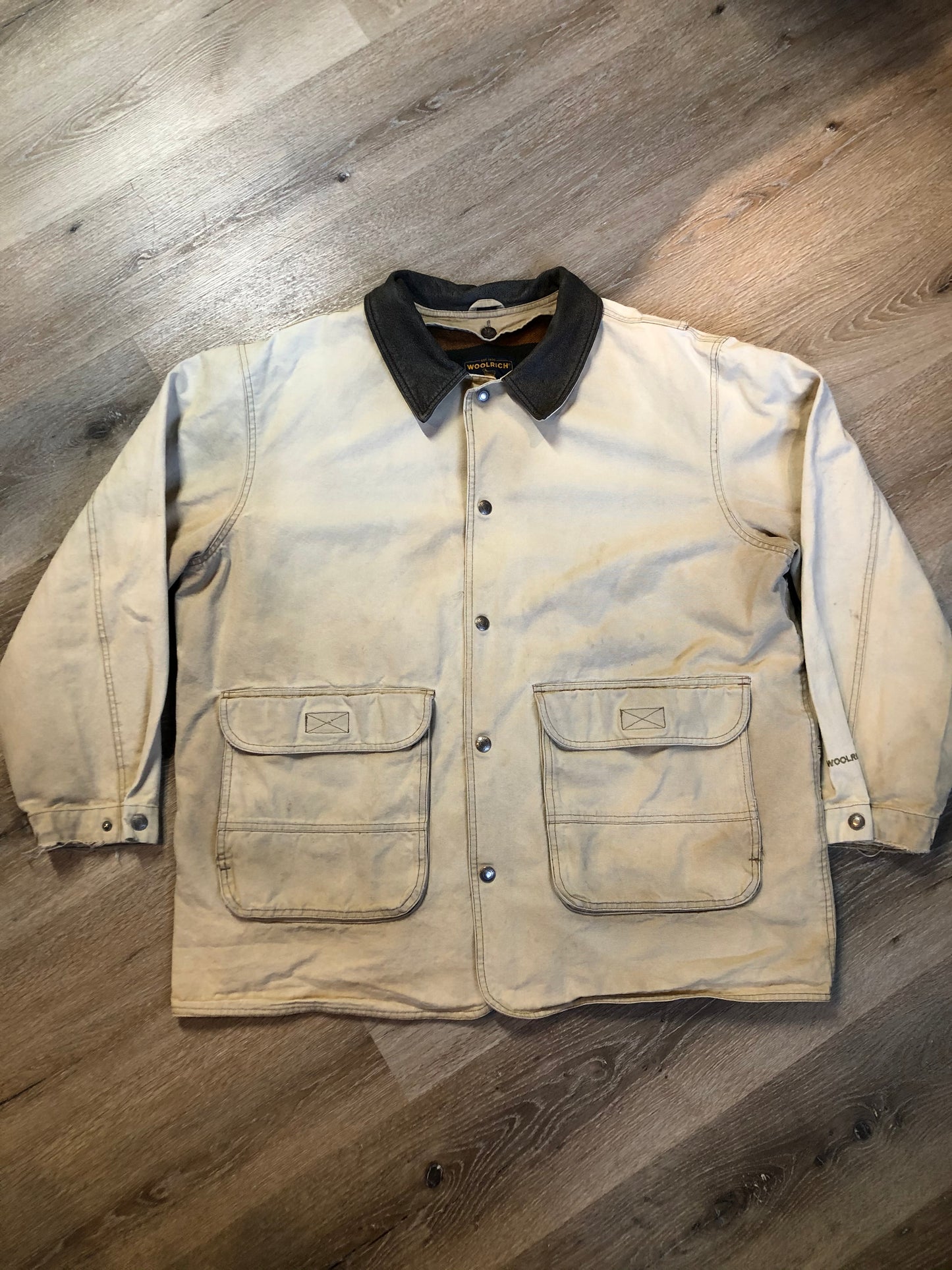 Kingspier Vintage - Woolrich beige chore jacket with cotton shell, leather collar, wool blend lining, snap closures and two flap pockets. Size XL.