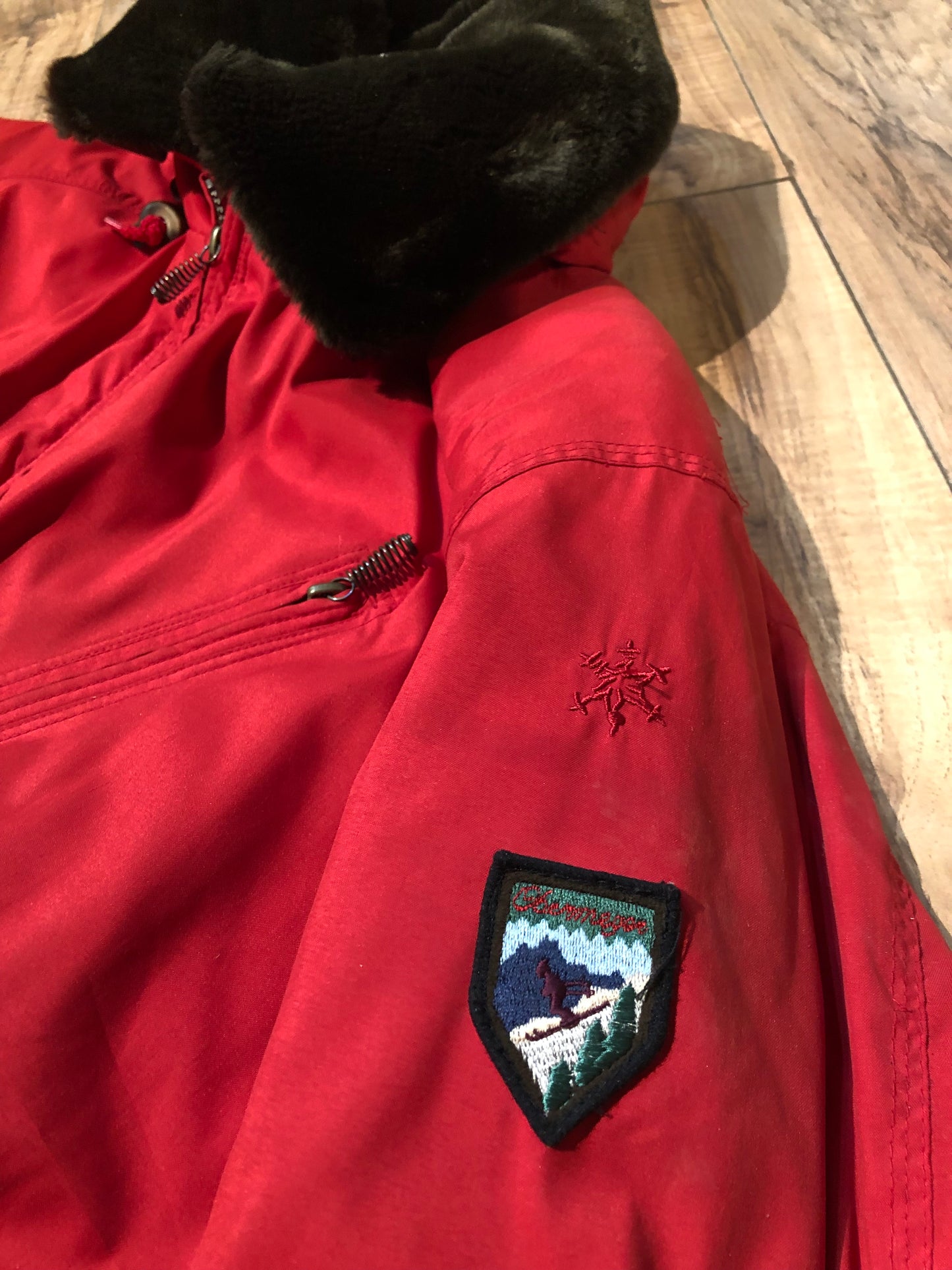 Kingspier Vintage - Vintage Obermeyer red one piece ski suit with suede belt, packable hood, quilted lining, zipper closure and multiple zip pockets.