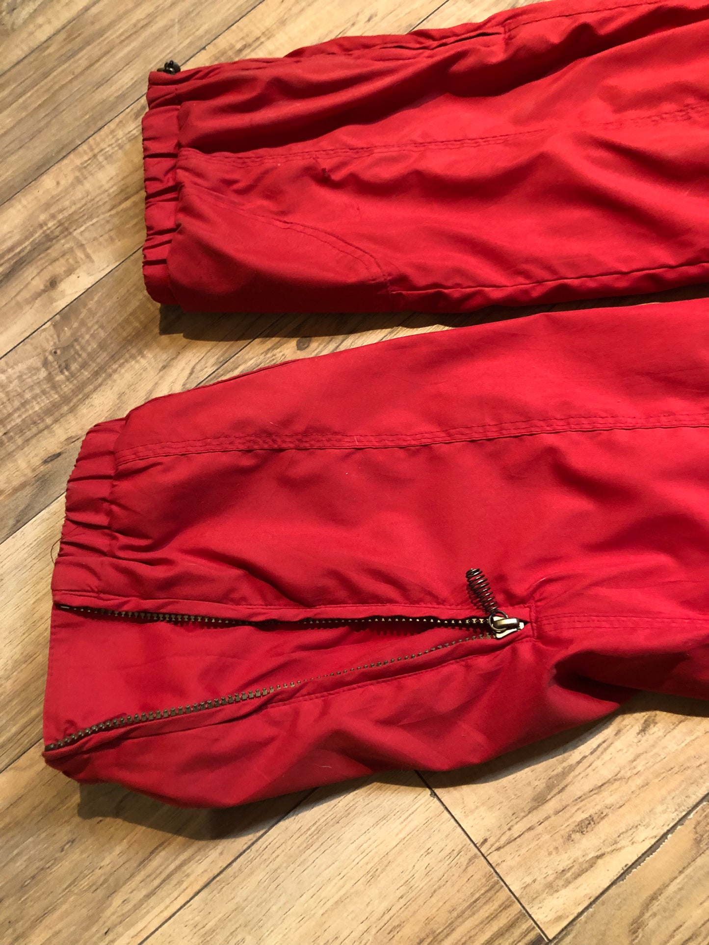 Kingspier Vintage - Vintage Obermeyer red one piece ski suit with suede belt, packable hood, quilted lining, zipper closure and multiple zip pockets.