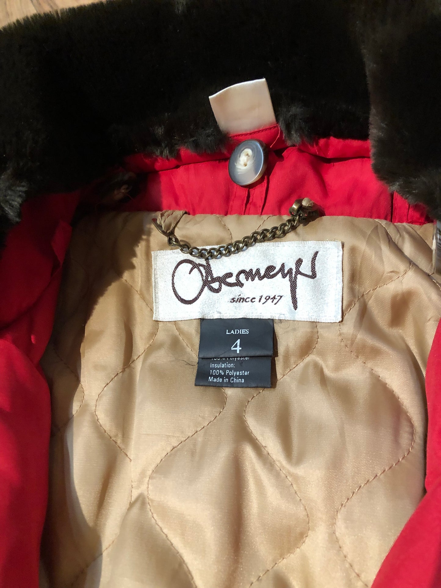 Kingspier Vintage - Vintage Obermeyer red one piece ski suit with suede belt, packable hood, quilted lining, zipper closure and multiple zip pockets.