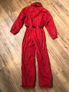 Kingspier Vintage - Vintage Obermeyer red one piece ski suit with suede belt, packable hood, quilted lining, zipper closure and multiple zip pockets.