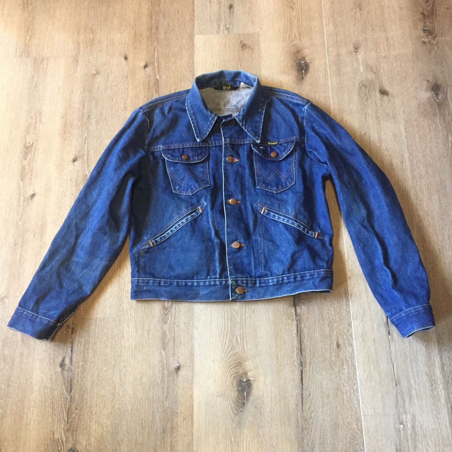 Kingspier Vintage - Vintage Wrangler medium wash denim jacket with iconic wrangler stitching, button closures, flap pockets on the chest and hand warmer pockets. Size medium. Made in USA.
