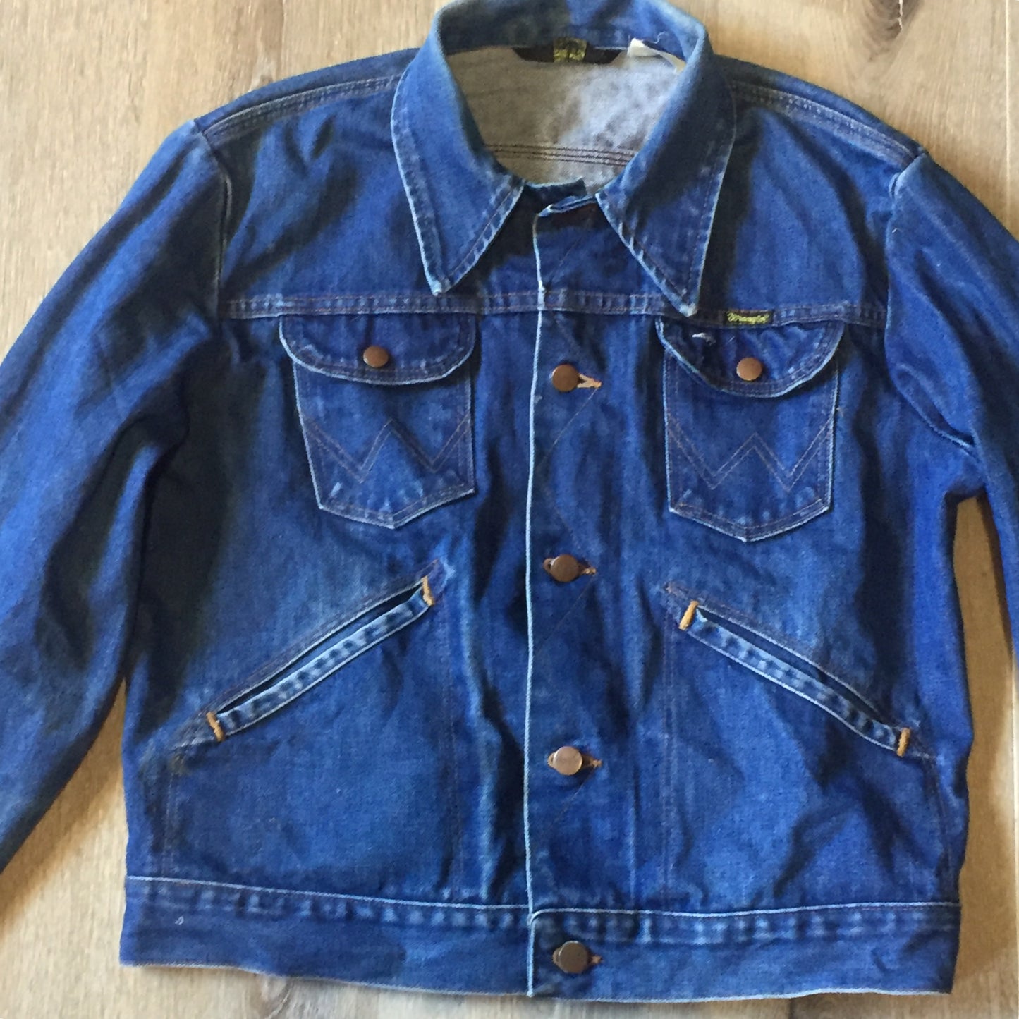 Kingspier Vintage - Vintage Wrangler medium wash denim jacket with iconic wrangler stitching, button closures, flap pockets on the chest and hand warmer pockets. Size medium. Made in USA.