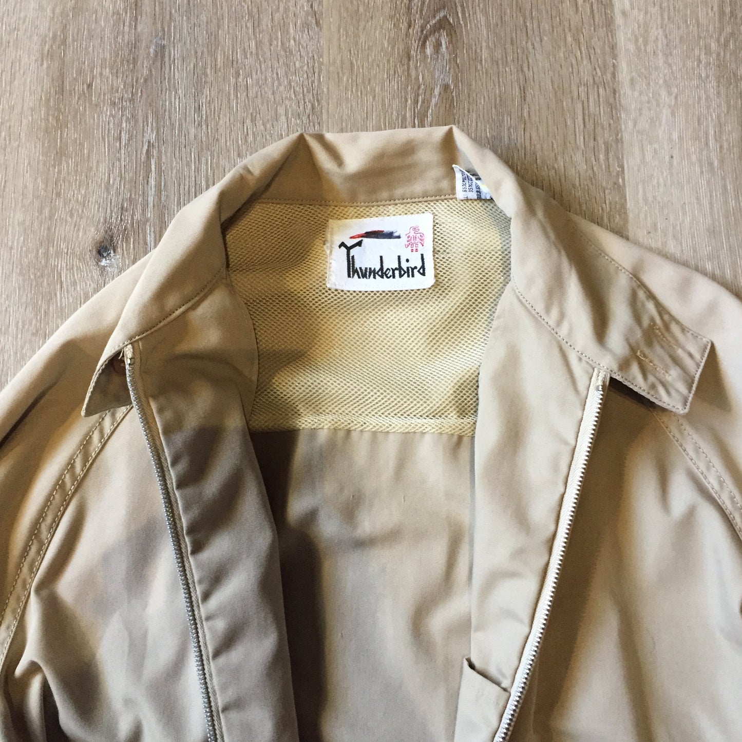 Kingspier Vintage - Vintage Thunderbird beige lightweight cotton/ poly blend jacket with zipper closure, slash pockets and nylon. Made in Korea. Size medium.