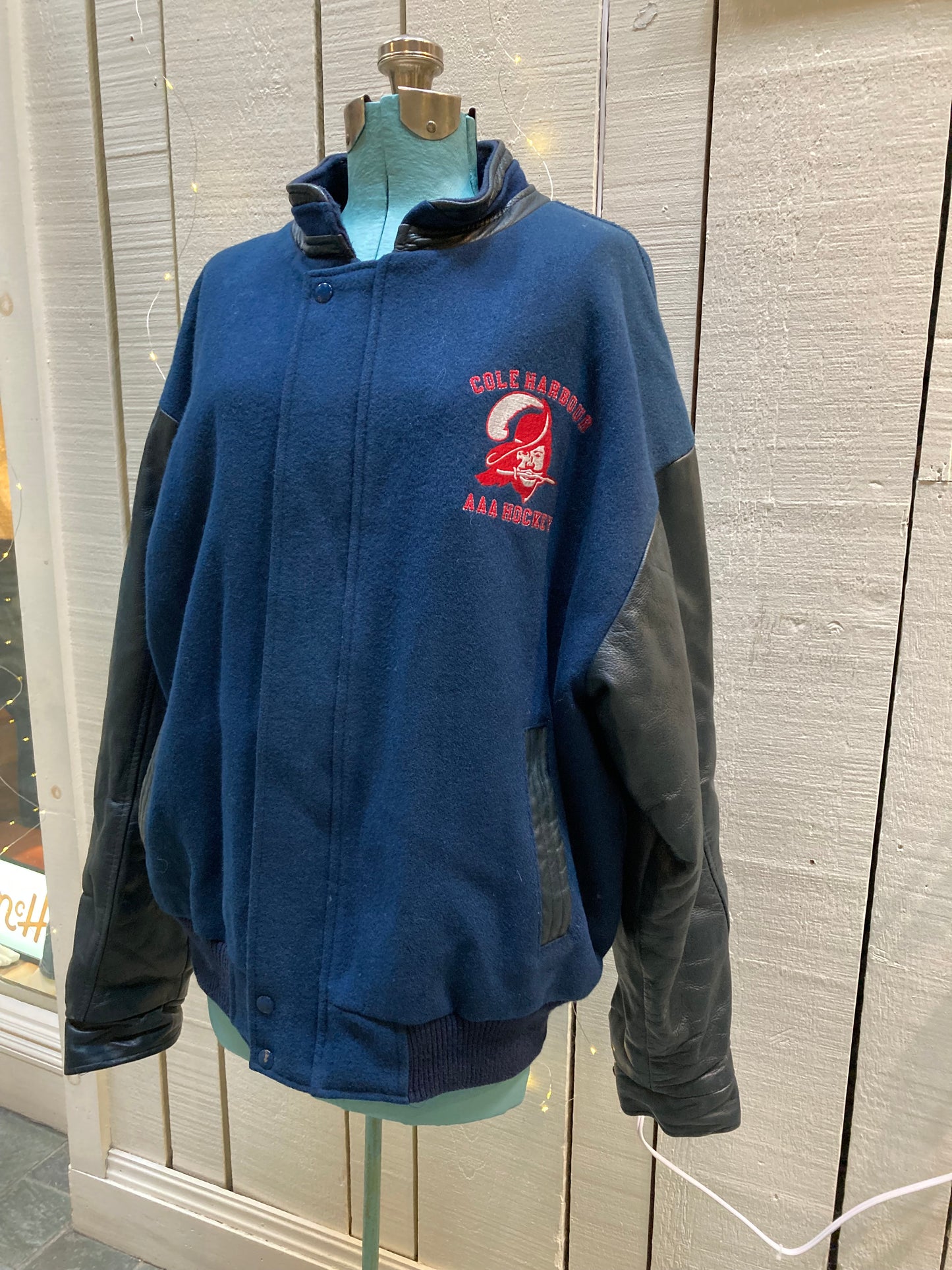 Kingspier Vintage - Vintage Cole Harbour AAA Hockey blue varsity jacket with leather arms, zipper and snap closure, two front pockets and a quilted lining.
Made in Canada.
Size XL.