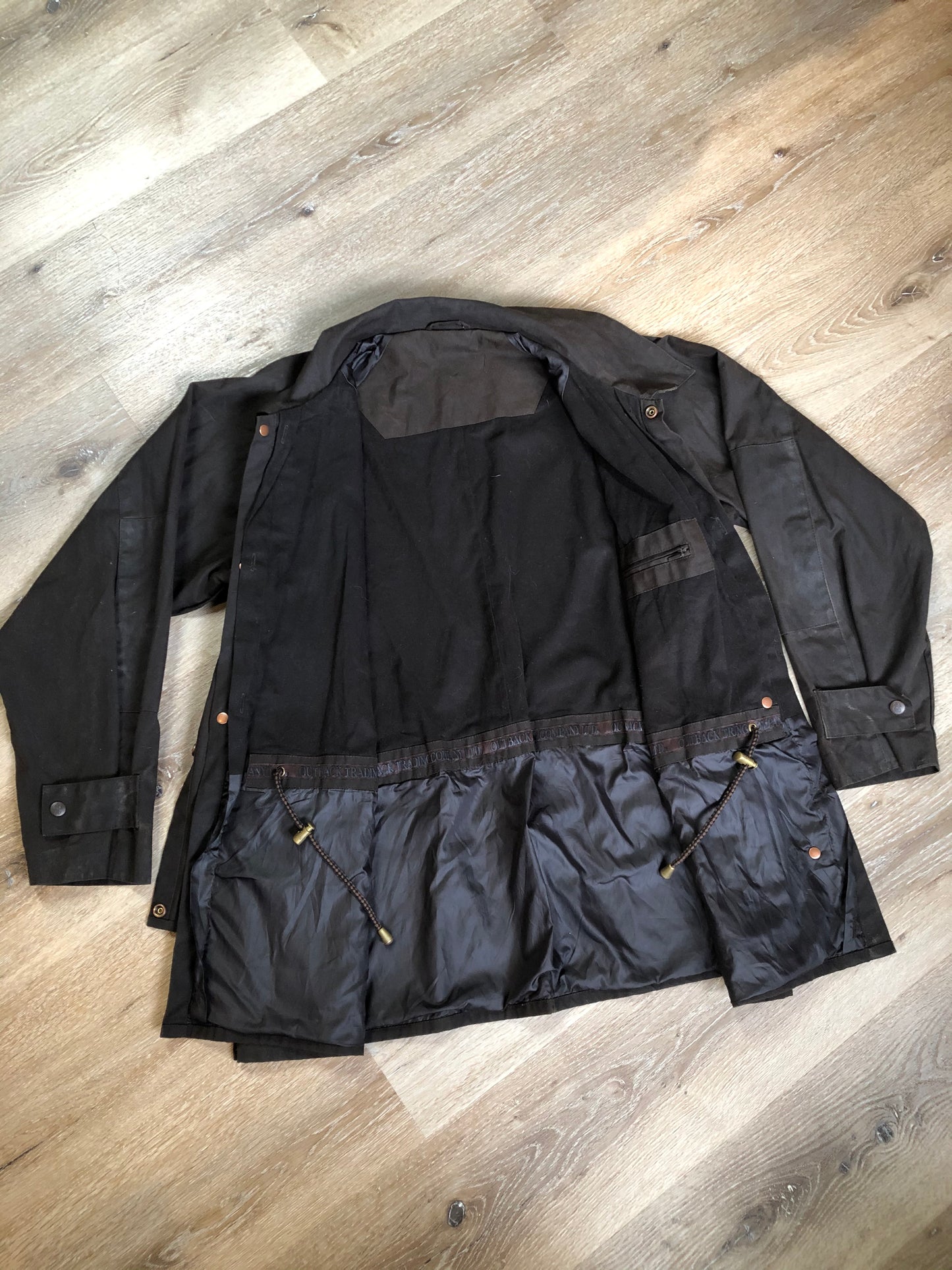 Kingspier Vintage - Outback Trading Co brown cotton oilskin rancher jacket with double snap closures, two snap flap pockets, one inside zip pocket, lightweight lining and drawstring at the waist. Fits large.