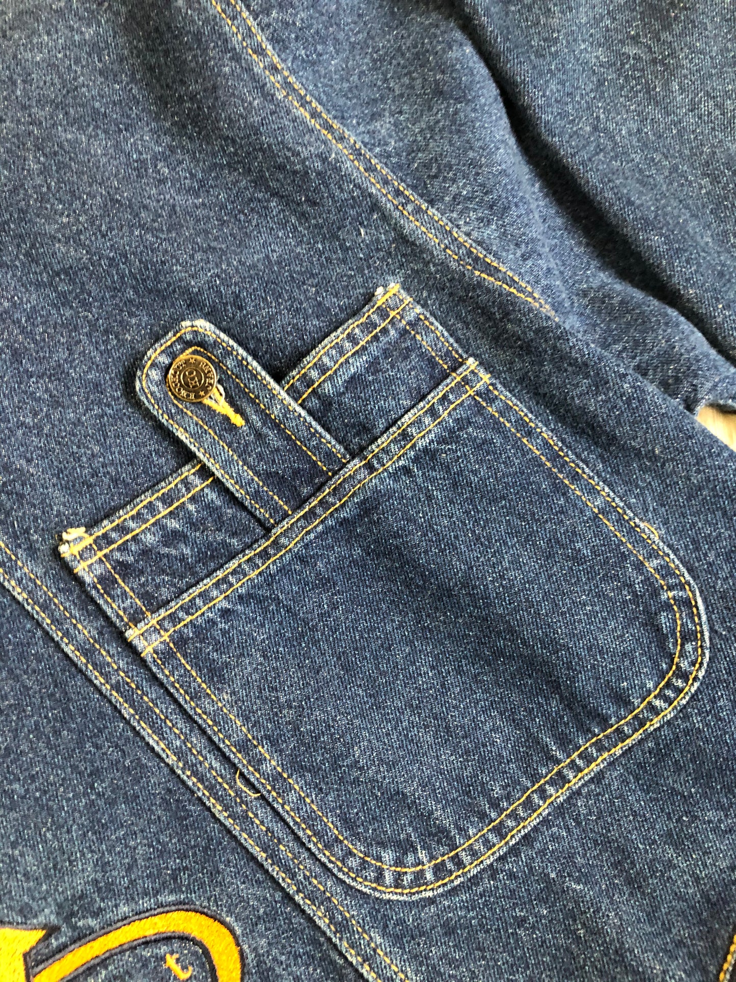 Kingspier Vintage - Vintage Knockout Jeans pullover denim jacket in a medium wash with quarter zip closure, embroidered logo on the front, knit cuffs, slash pockets, one patch pocket on the chest and a leather patch on the back. Size Xl. Made in USA