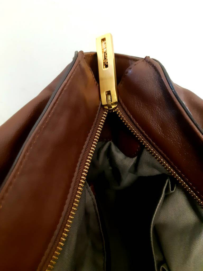 Kingspier Vintage - <p>Beautiful roomy hand bag with exquisitely designed hardware. <br>
The leather and lining are pristine with no evidence of wear.<br>
There is a zippered inner pocket and two pouches designed for glasses or cell phone.</p>