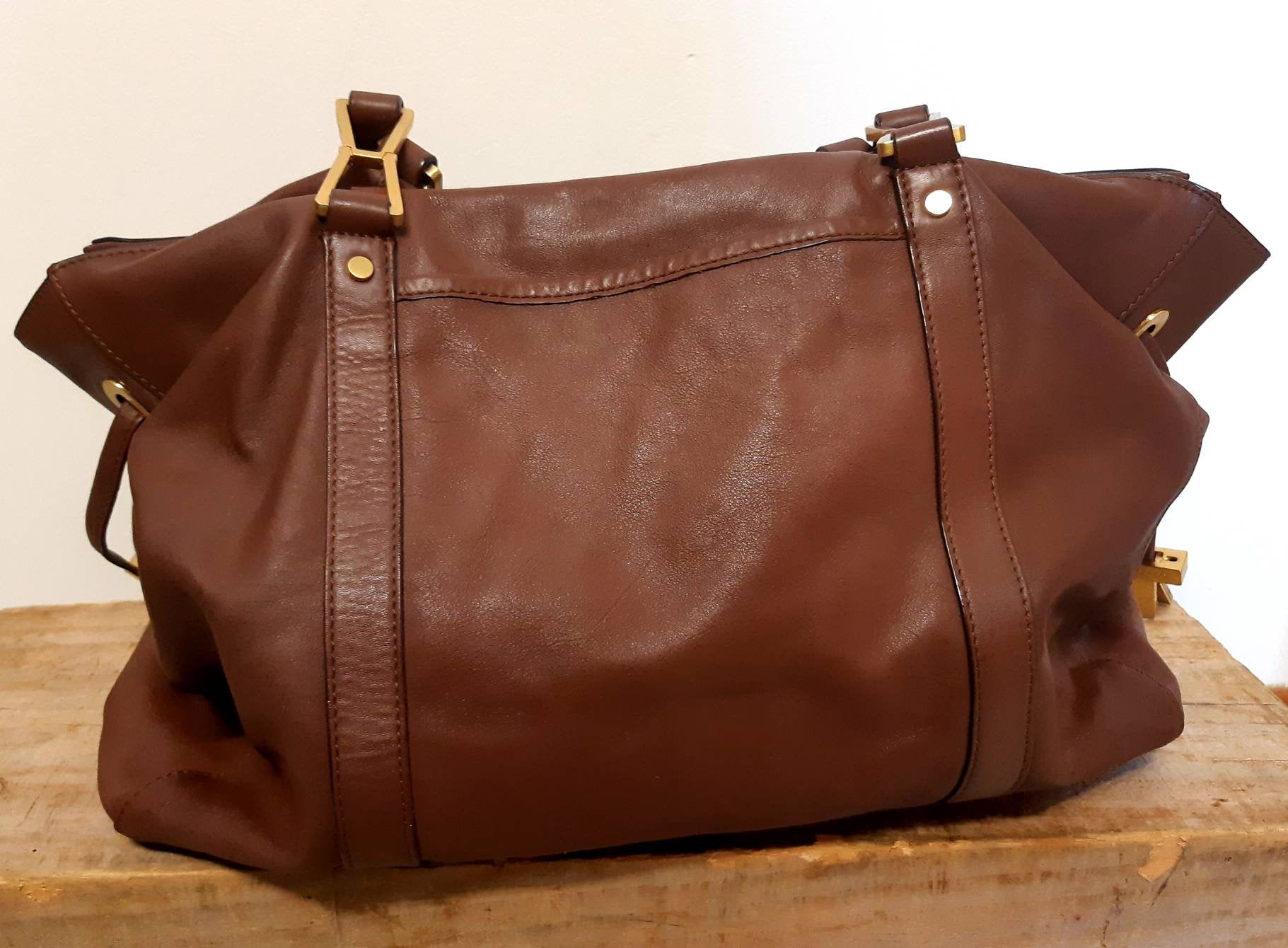 Kingspier Vintage - <p>Beautiful roomy hand bag with exquisitely designed hardware. <br>
The leather and lining are pristine with no evidence of wear.<br>
There is a zippered inner pocket and two pouches designed for glasses or cell phone.</p>