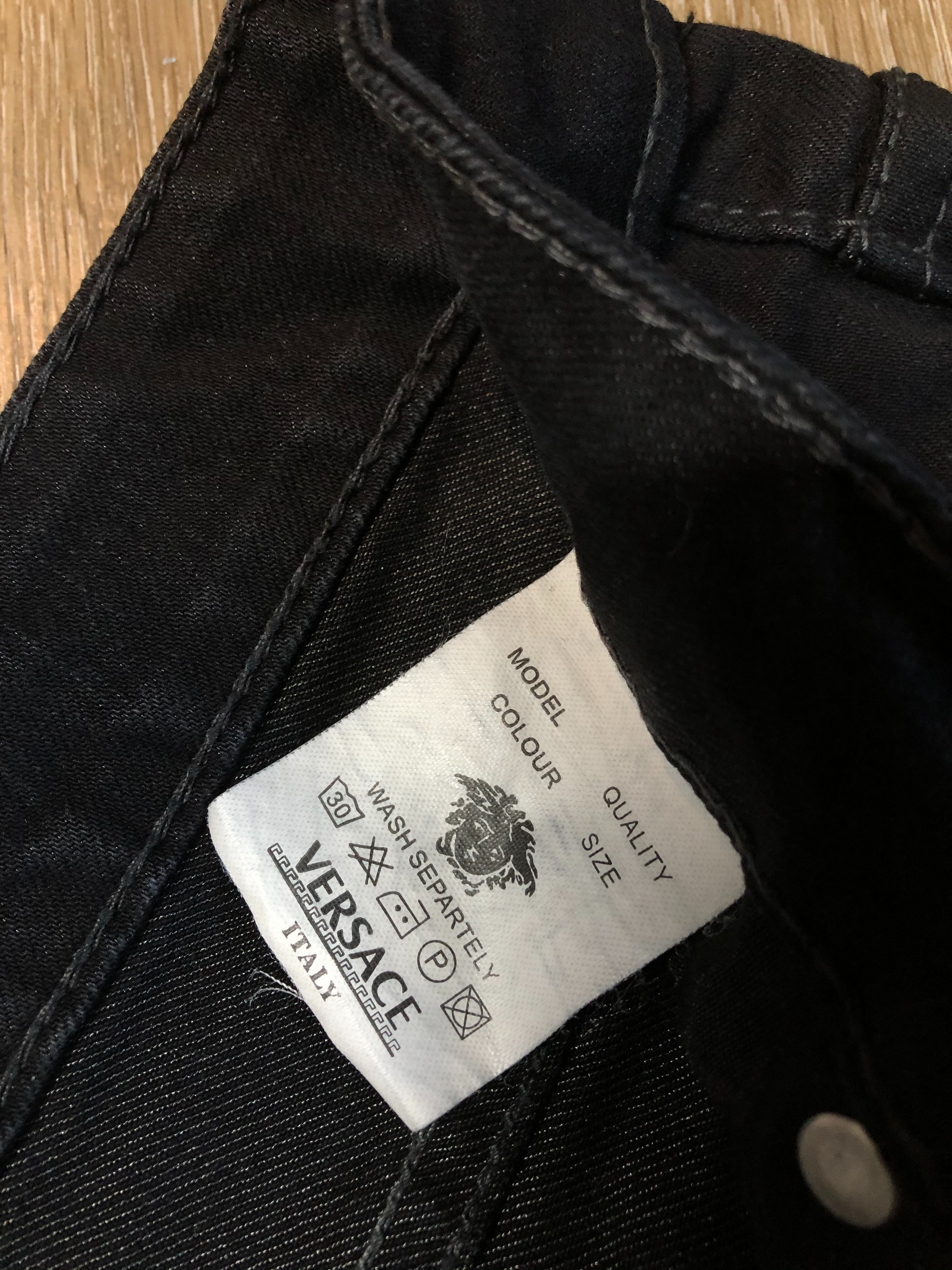 Kingspier Vintage - Versace black denim skinny jeans with metal Versace emblem on the back. Made in Italy. Size 27.