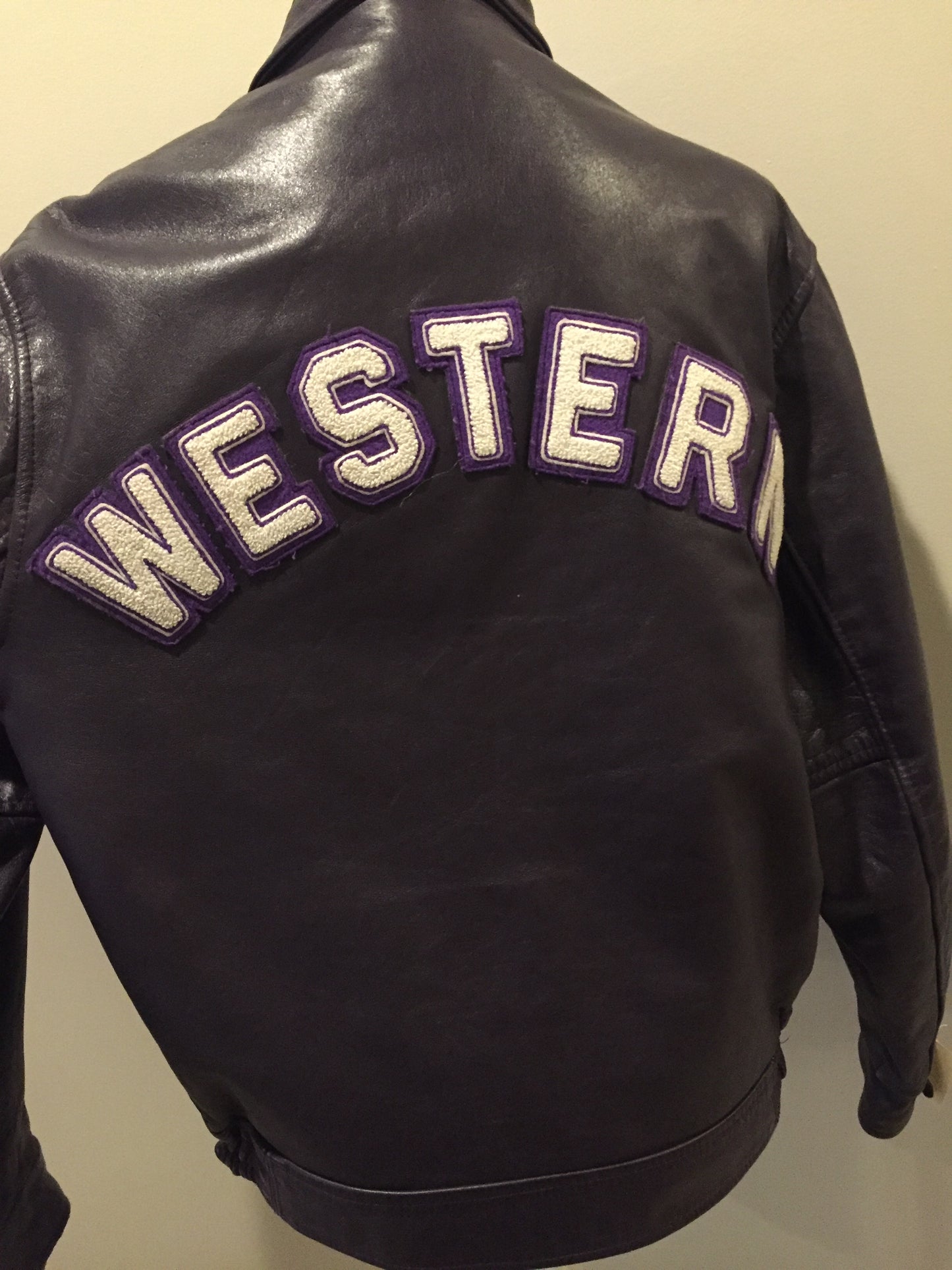 Kingspier Vintage - Western University leather varsity jacket in deep purple with slash pockets and snap closures, emblem embroidered on the chest and “Western” written across the back.