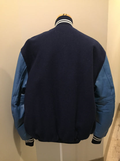 Kingspier Vintage - Blue wool varsity jacket with blue leather arms, snap closures, slash pockets and red quilted lining. Size 44.