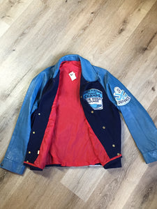 Kingspier Vintage - Trinity Placentia Senior Champs “Blue Whale Lounge “ blue varsity jacket with snap closures, slash pockets, embroidered emblem on chest and arm, “whalers” written across the back and a red lining. Size 44.
