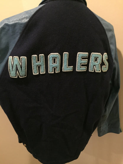 Kingspier Vintage - Trinity Placentia Senior Champs “Blue Whale Lounge “ blue varsity jacket with snap closures, slash pockets, embroidered emblem on chest and arm, “whalers” written across the back and a red lining. Size 44.