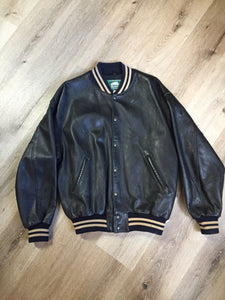 Kingspier Vintage - Roots leather varsity jacket in black with blue and brown ribbing, snap closures and slash pockets. Size large.