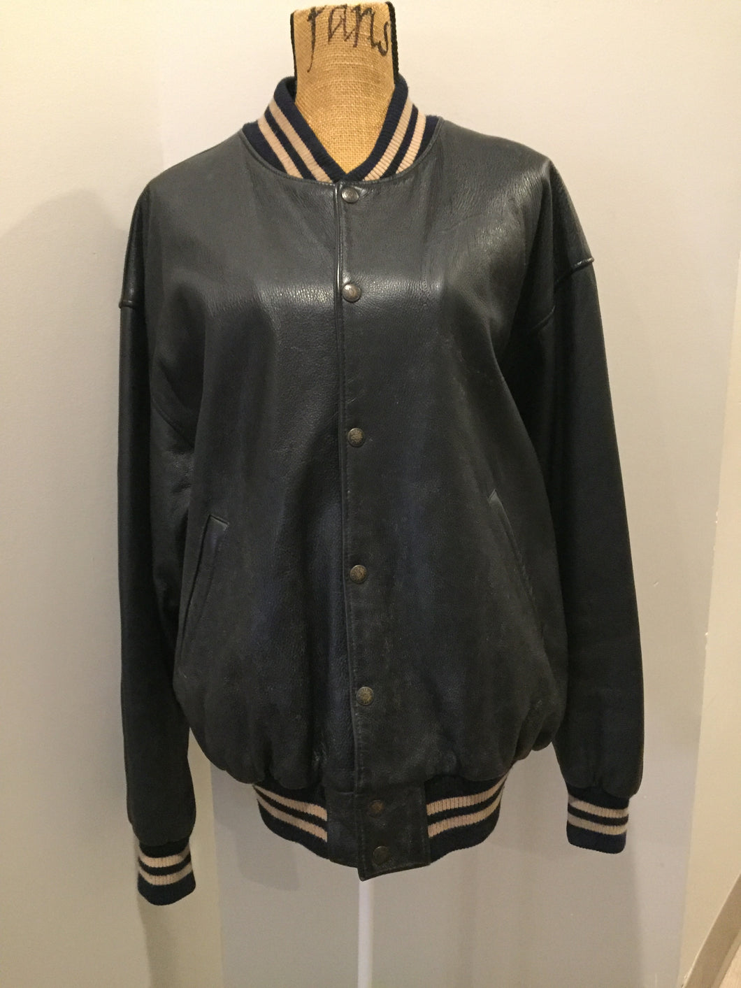 Kingspier Vintage - Roots leather varsity jacket in black with blue and brown ribbing, snap closures and slash pockets. Size large.