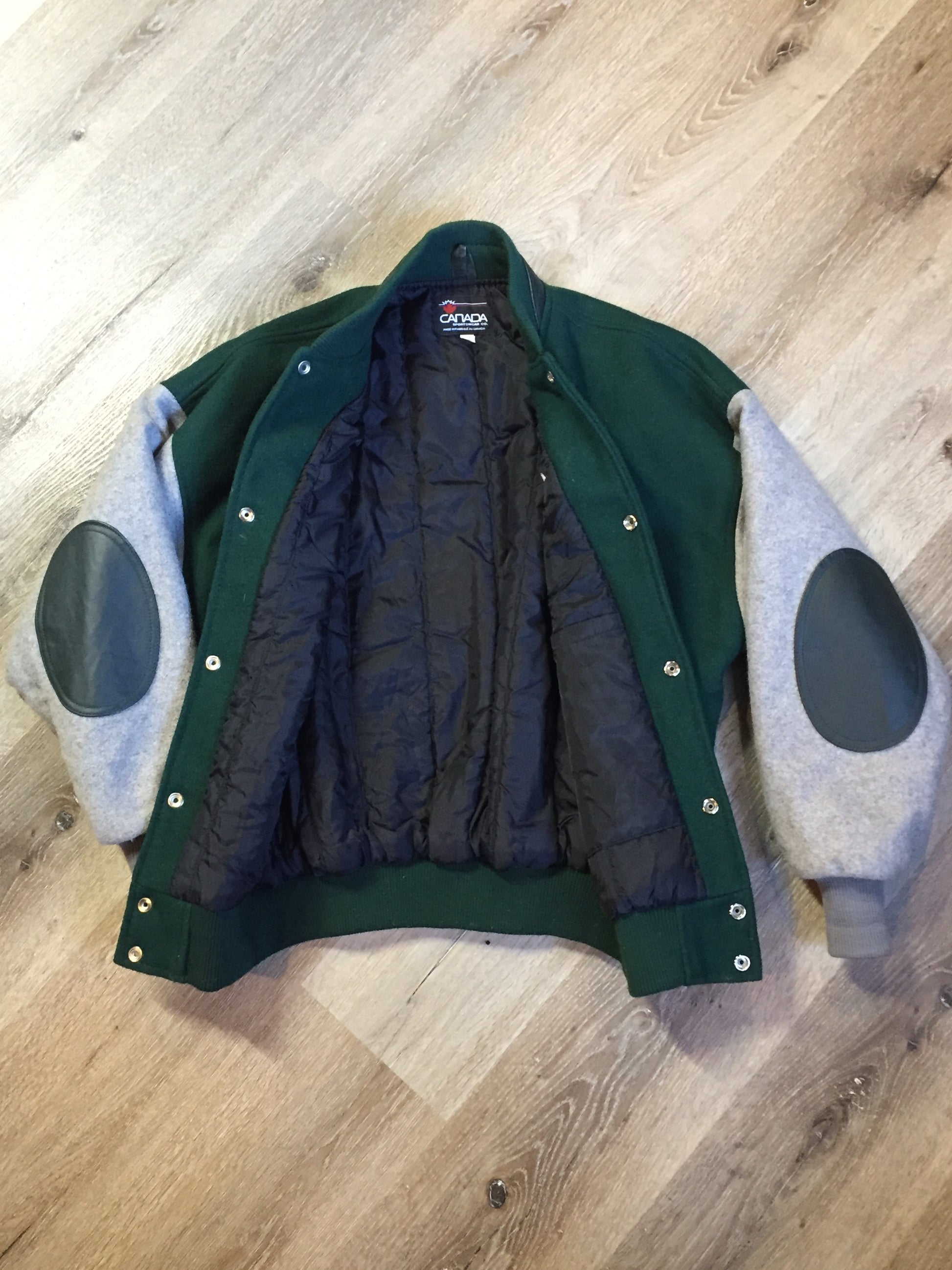 Kingspier Vintage - Mayflower Curling wool varsity jacket in green and grey with black leather accents, snap closures, slash pockets and emblem on chest. Made in Canada.