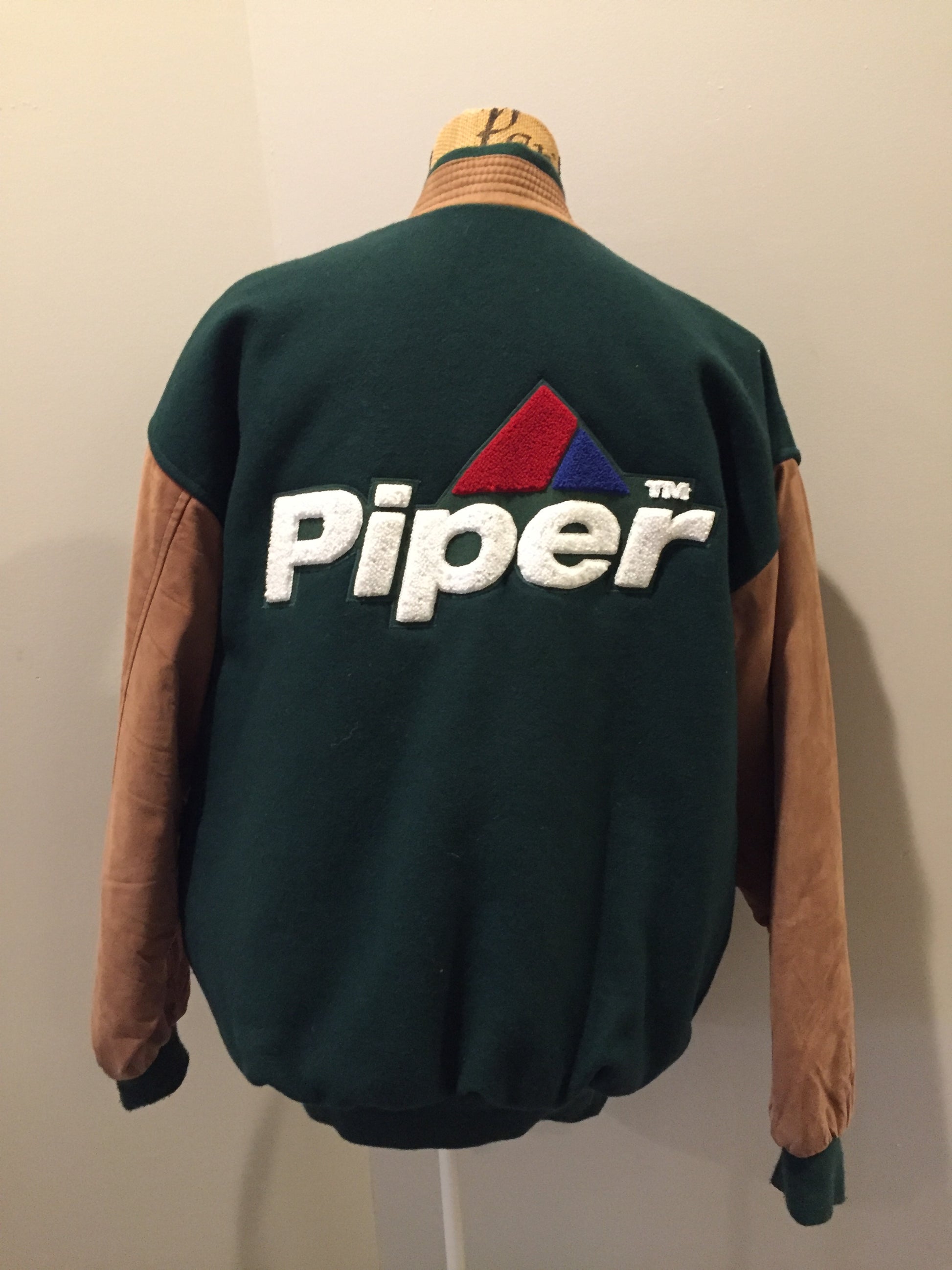 Kingspier Vintage - Piper leather/mouton varsity jacket in green and brown with “Aviation Limited” written on the chest and “Piper” written on the back, snap closures, slash pockets, quilted lining and inside pocket. Made in Canada.