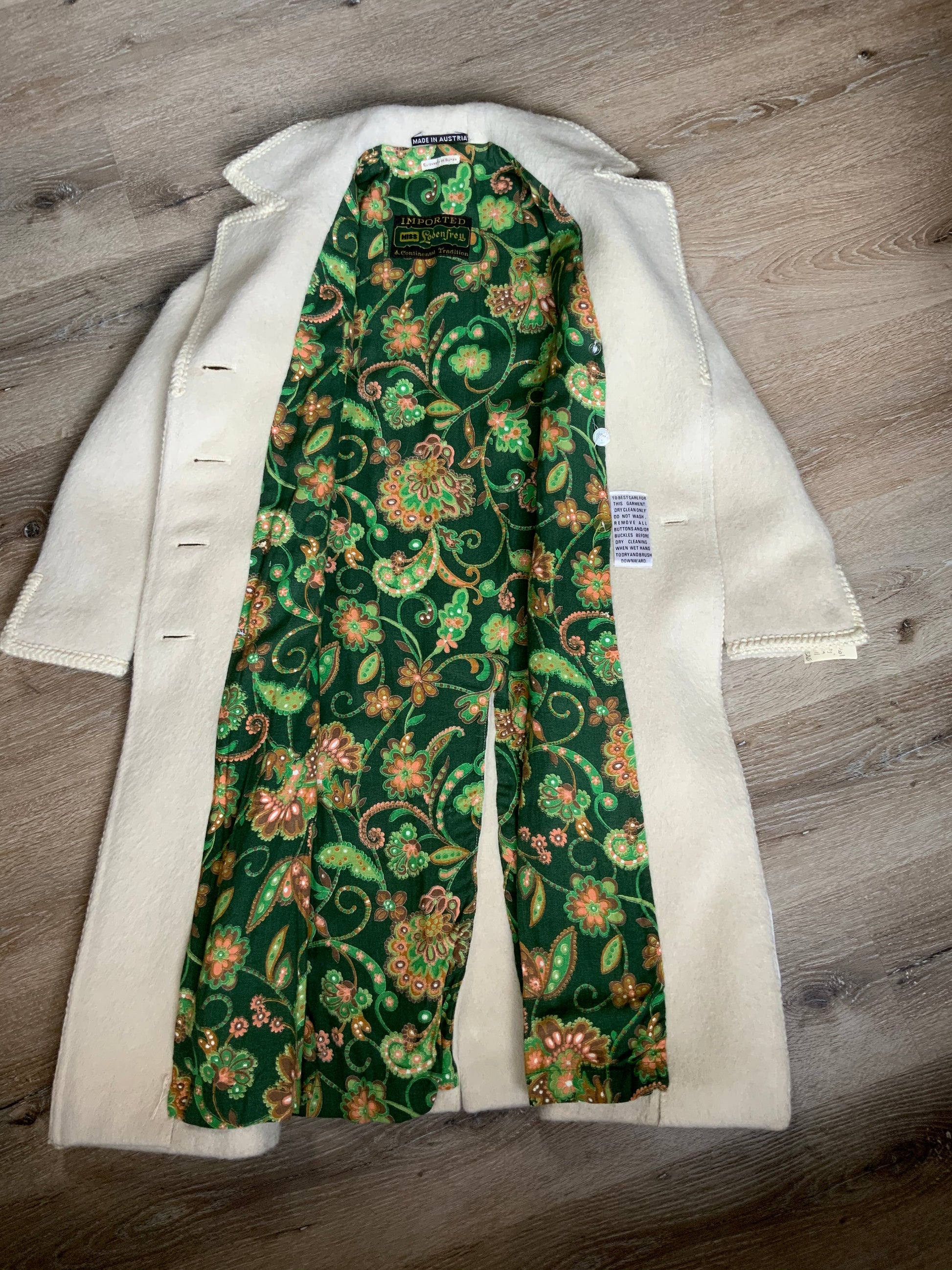 Kingspier Vintage - Miss Lodenfrey white Australian wool coat with lovely braided trim detailing, double breasted with button closures and front pockets. This coat features a bright green paisley lining. Made in Austria. Size small.